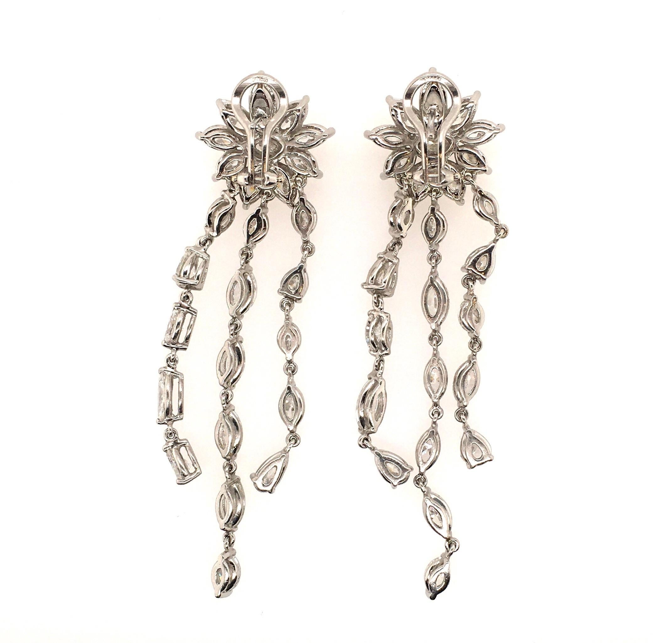 A pair of 18 karat white gold and diamond earrings.  Designed as a marquise and circular cut diamond florets, suspending marquises and pear shaped diamond fringe. Fifty four (54) diamonds weigh approximately 13.94 carats. Length is approximately 3