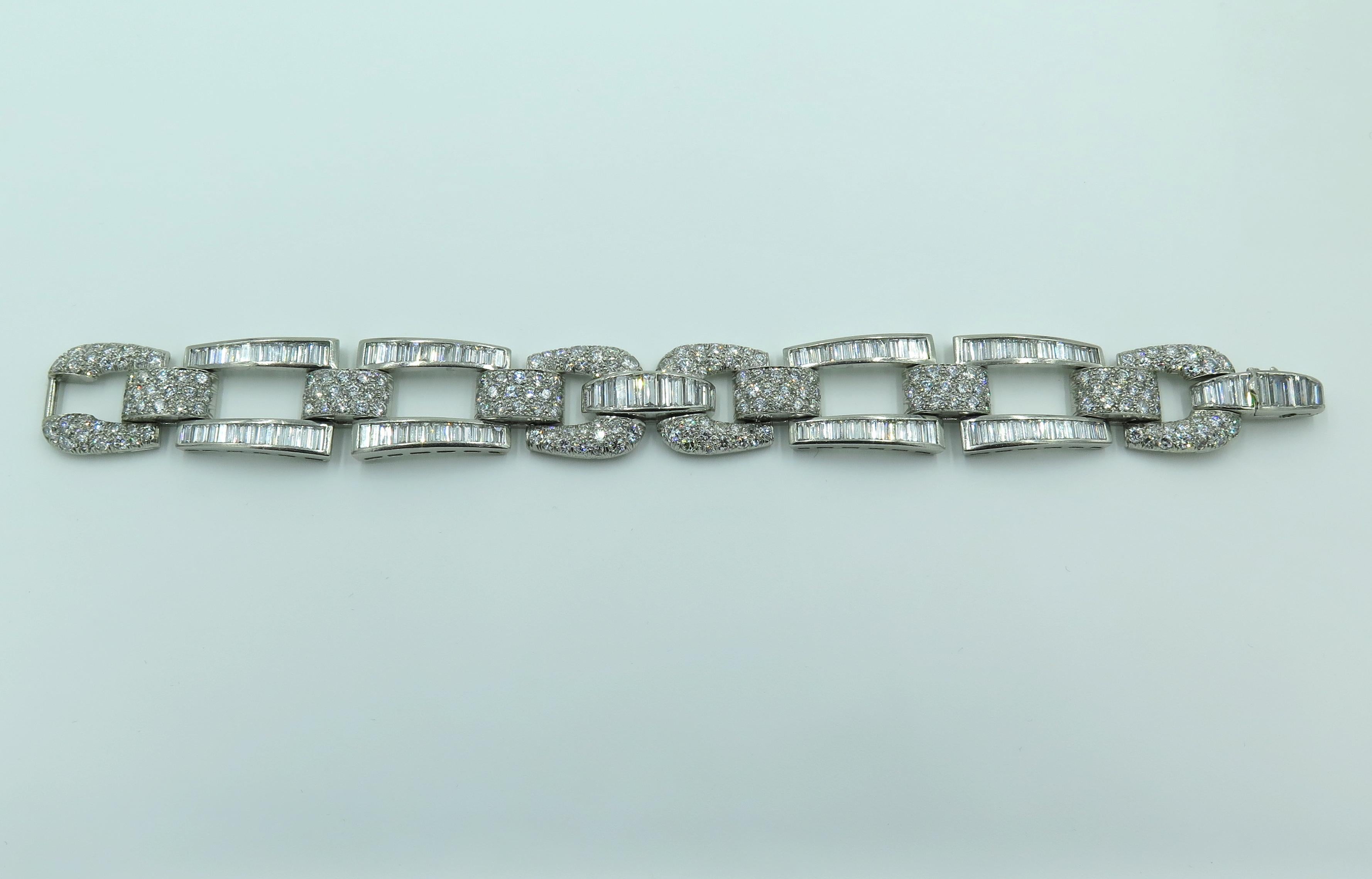 A platinum and diamond bracelet. Circa 1950. Designed as rectangular baguette cut diamond set links,  alternating with pave set horse shoe shaped links and spacers. One hundred and thirty six baguette cut diamonds weigh approximately 13.00 carats