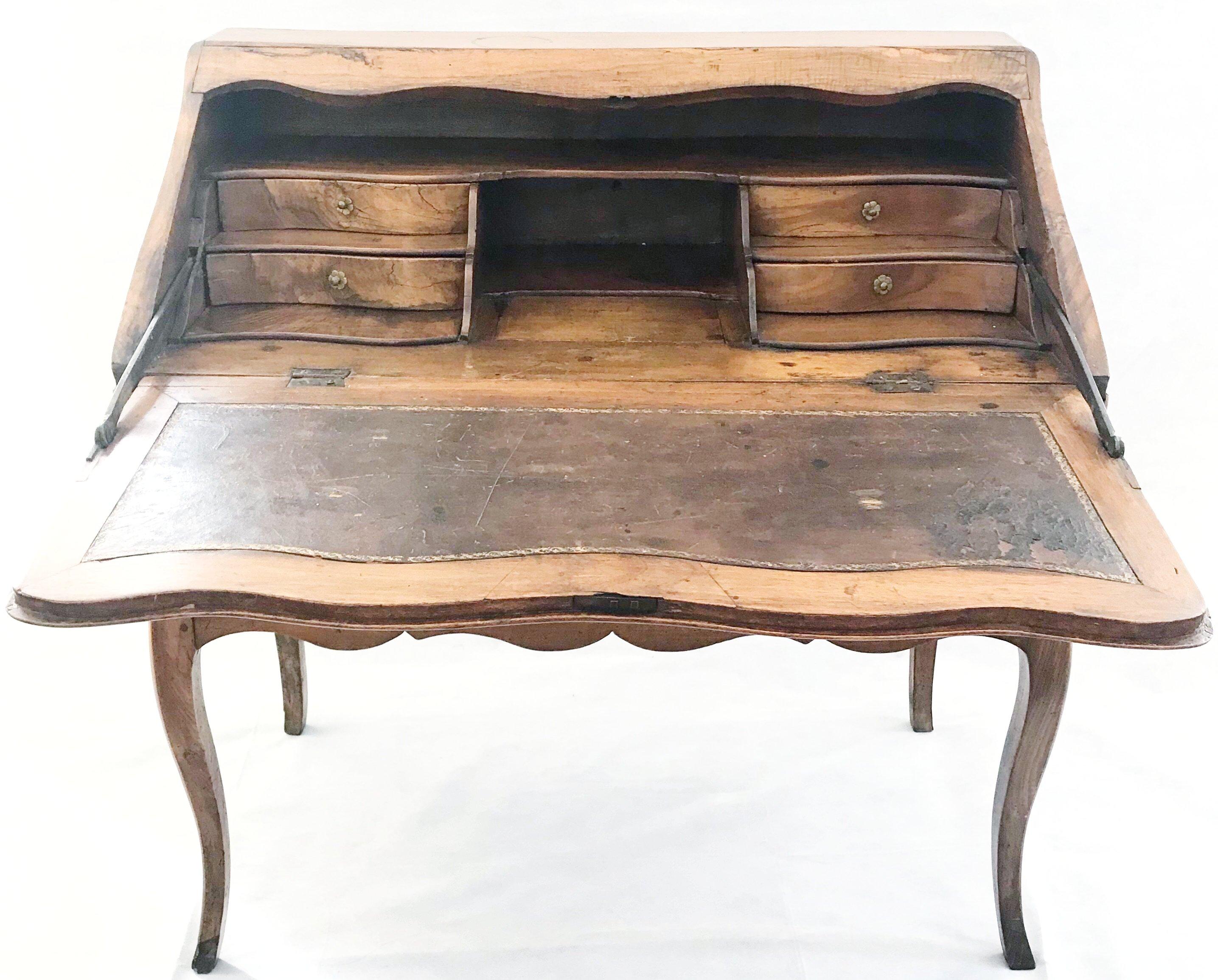 Beautiful antique French Louis XV slant front desk with cabriole legs, original leather writing pad and four curved side drawers surrounding center compartment. Some early repair to legs. Excellent shape for its age and beautiful patina.