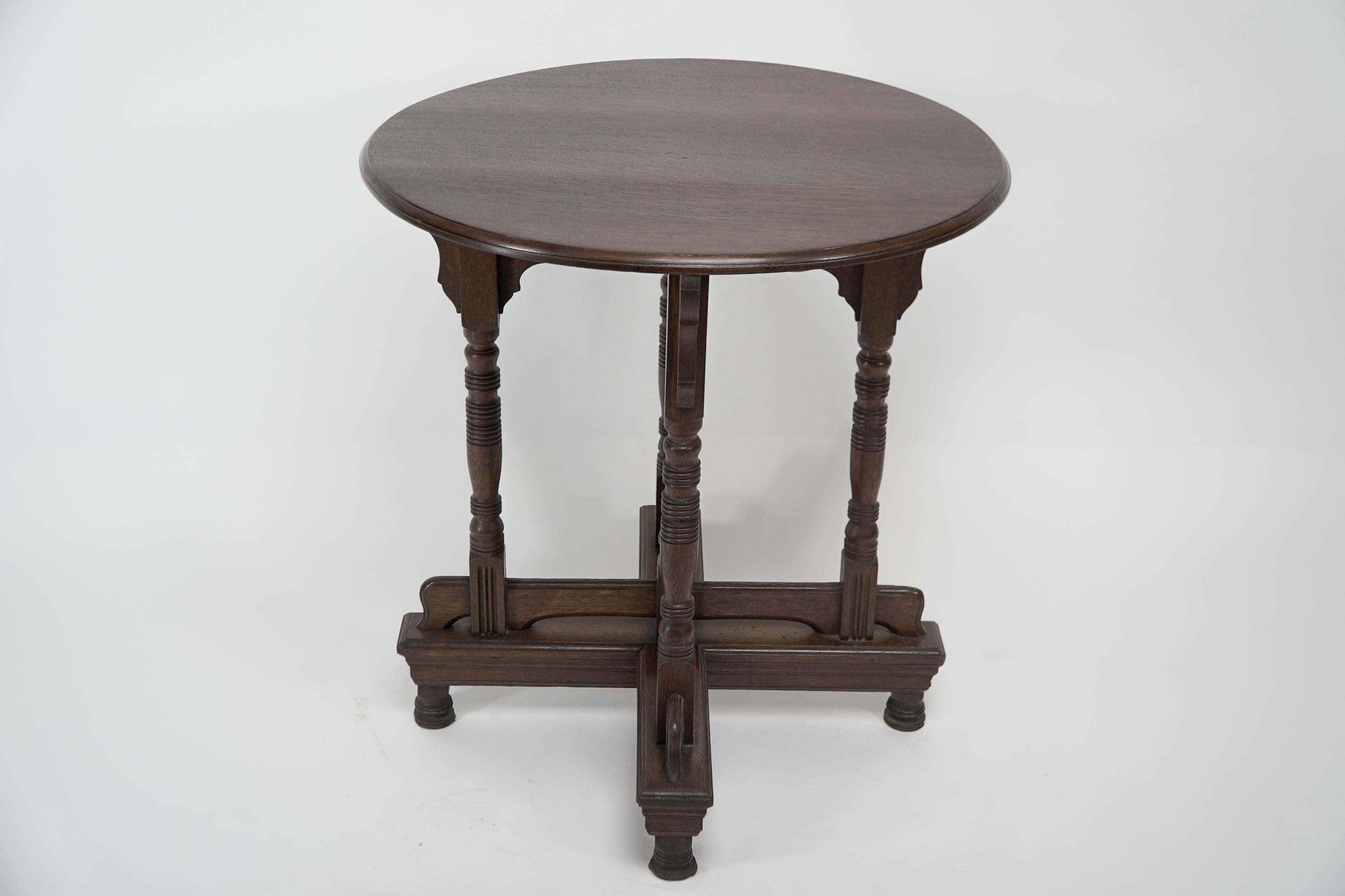 Alfred Waterhouse attributed. A Gothic Revival oak side table with unusual double cross stretchers uniting the turned legs, the upper cross stretcher with a turned finial to the center on turned stub feet.