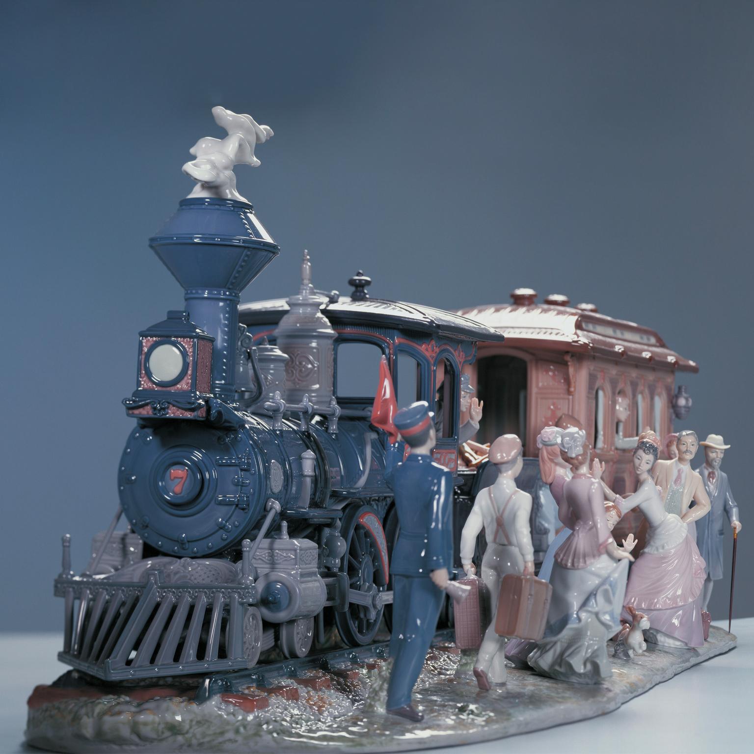 Limited edition steam locomotive with wagon and figures holding handmade umbrellas in gloss finish porcelain.
All on board! The whistle blows and the passengers are ready to embark on a exciting adventure. It is demanding challenge for the Lladró