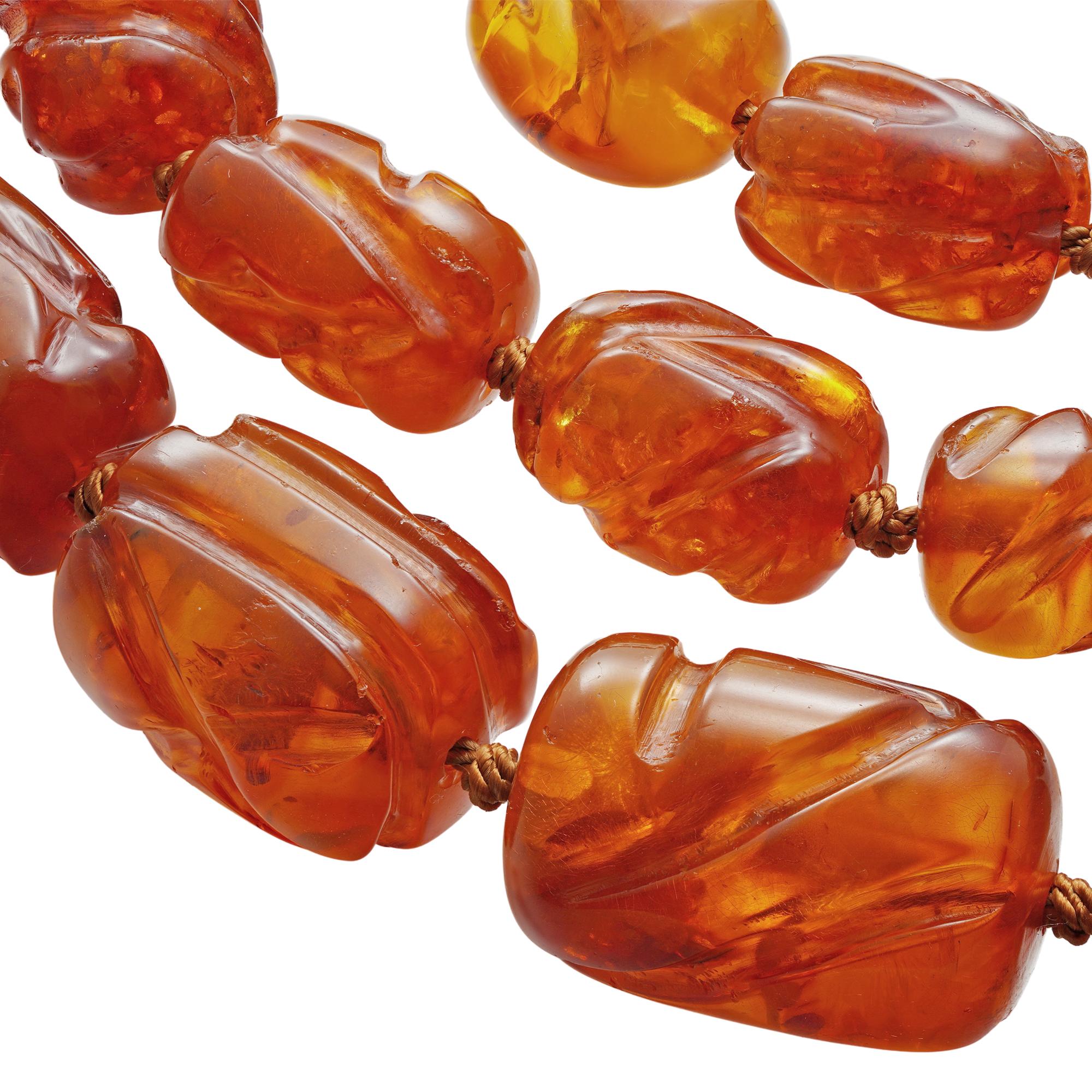 A Grand amber necklace, the 34 graduated carved amber beads with distinctive spangle inclusions, length 50cm, gross weight 263.8 grams

This striking amber necklace comes from the collection of Bentley & Skinner, the London jewellers by appointment