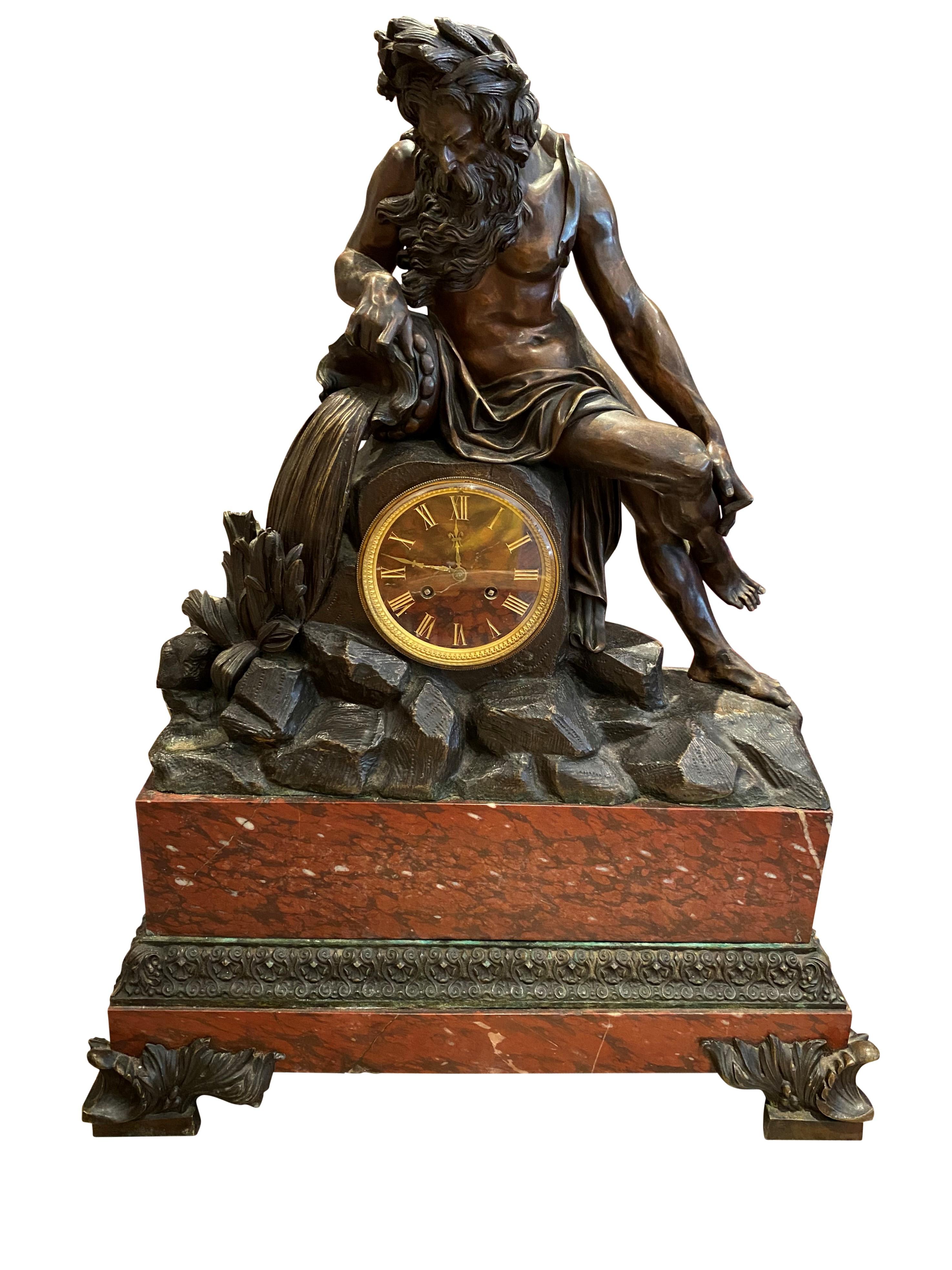 A rare French gilt and patinated bronze mantle clock with on top a statue of Neptune, on a rouge imperial marble base, circa 1860s (1880). This impressive piece stands over 2.6 feet tall. A monumental piece, perfect for home decoration, with