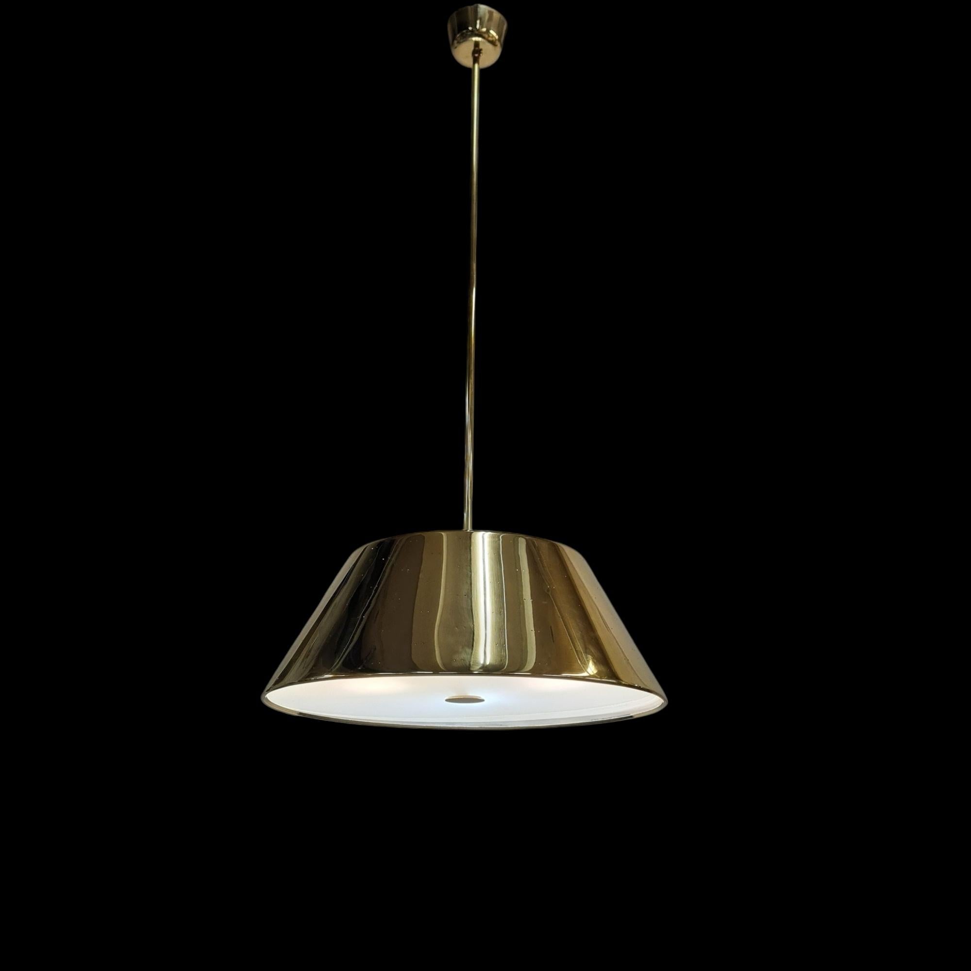 Eine große Deckenleuchte aus Messing vom Meister des finnischen Beleuchtungsdesigns Paavo Tynell. Diese große Messinglampe hat einen Durchmesser von 60 cm und ist damit wesentlich größer als die üblichen Modelle mit 40-50 cm. Die Hängeleuchte hat