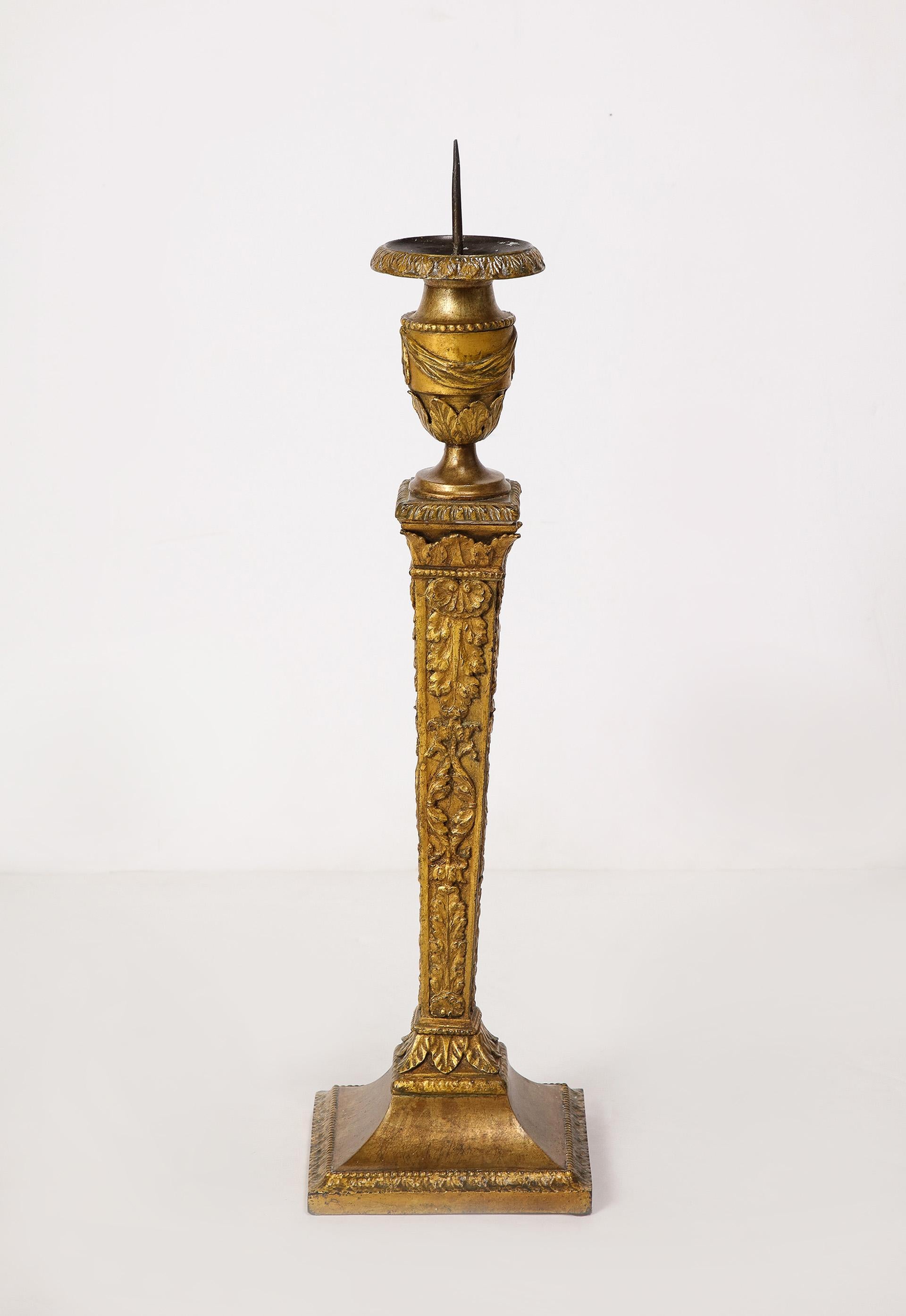 This grand pair of empire gilt iron candlesticks of typical form, having an intricately detailed surface with gilt finish.