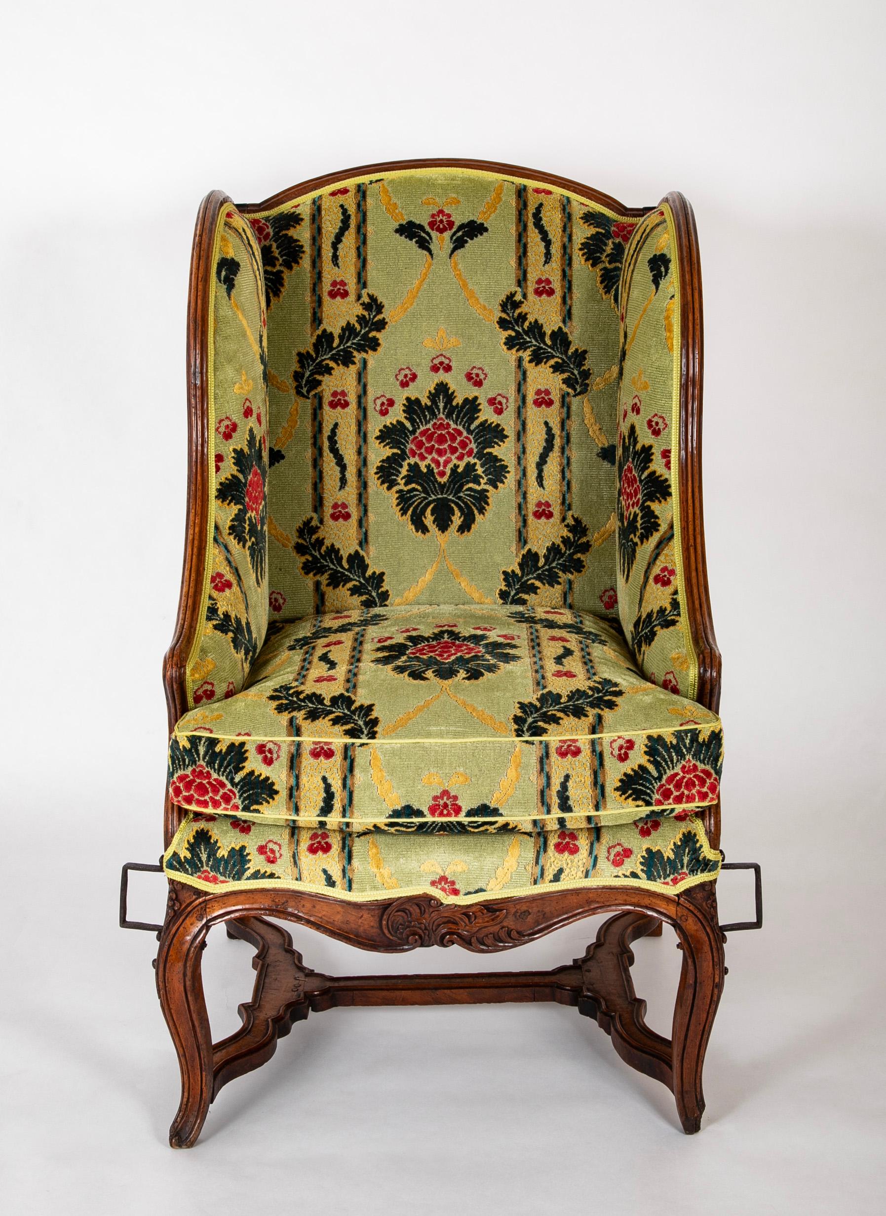 Ein schöner französischer Sessel aus geschnitztem Nussbaumholz aus der Louis-XV-Periode, der später mit handgeschmiedeten Eisenbügeln für den Gebrauch in Sänften angepasst wurde.  18. Jahrhundert.