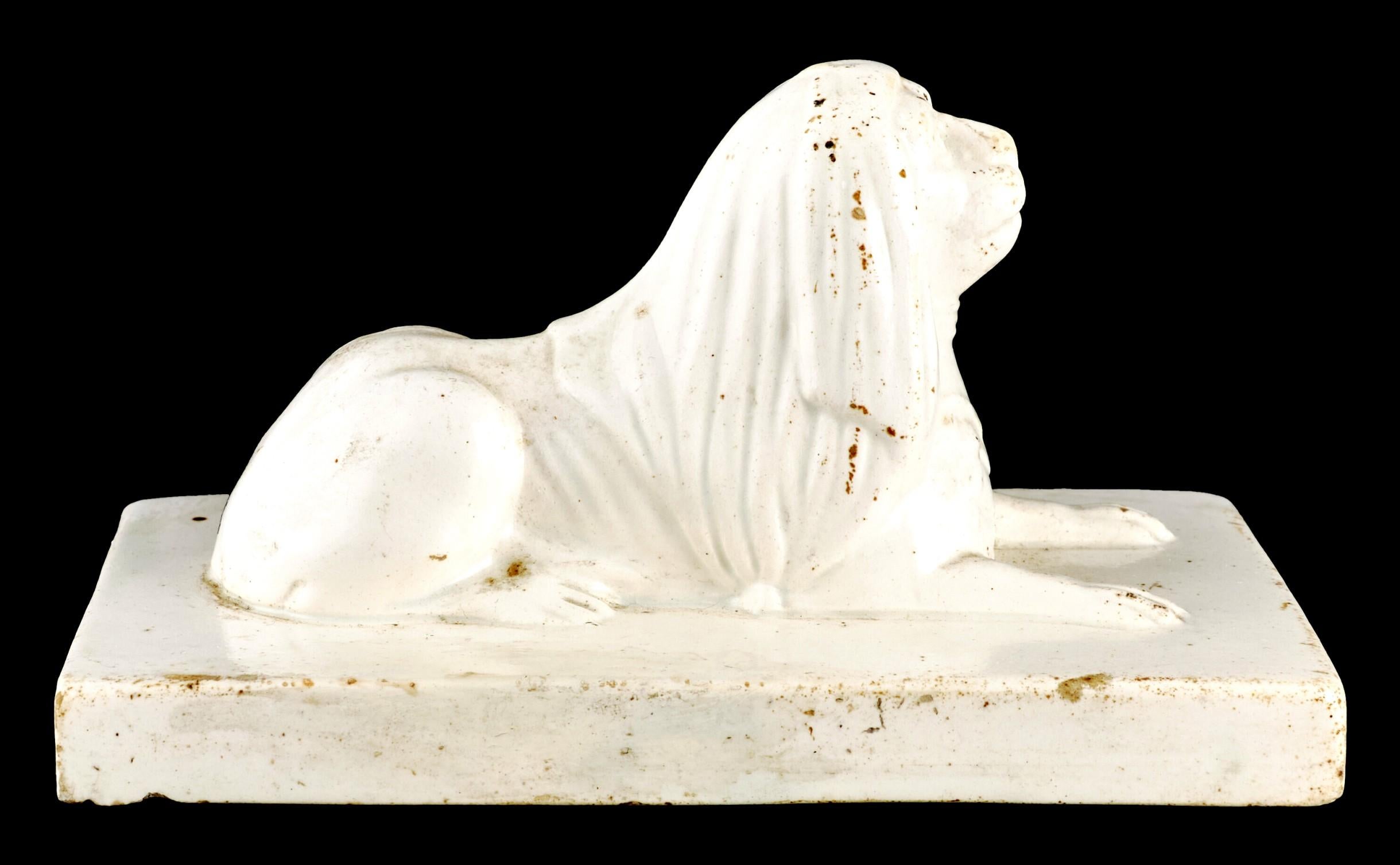 A very handsome ceramic Grand Tour desk top model of the Capitoline Lion. The molded recumbent figure of a lion shown outstretched atop an integral rectangular base. 
The origin of the Capitoline Lion is derived from an ancient marble group known as