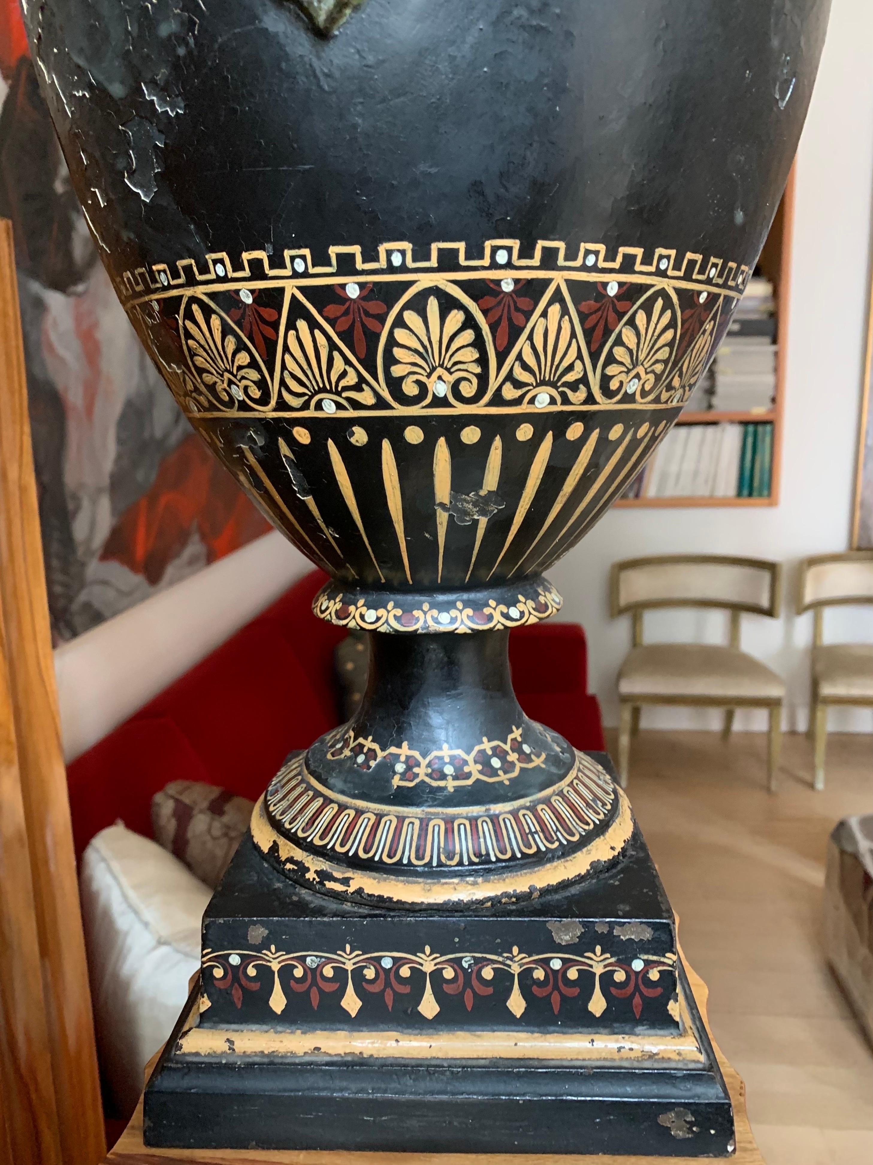 A beautiful Gran Tour vase, of Etruscan inspiration in cast iron, decorated with geometric and vegetal drawings, both on the base and in other parts of the vase, it has two ring-shaped handles that emerge from a relief also with vegetal decoration.