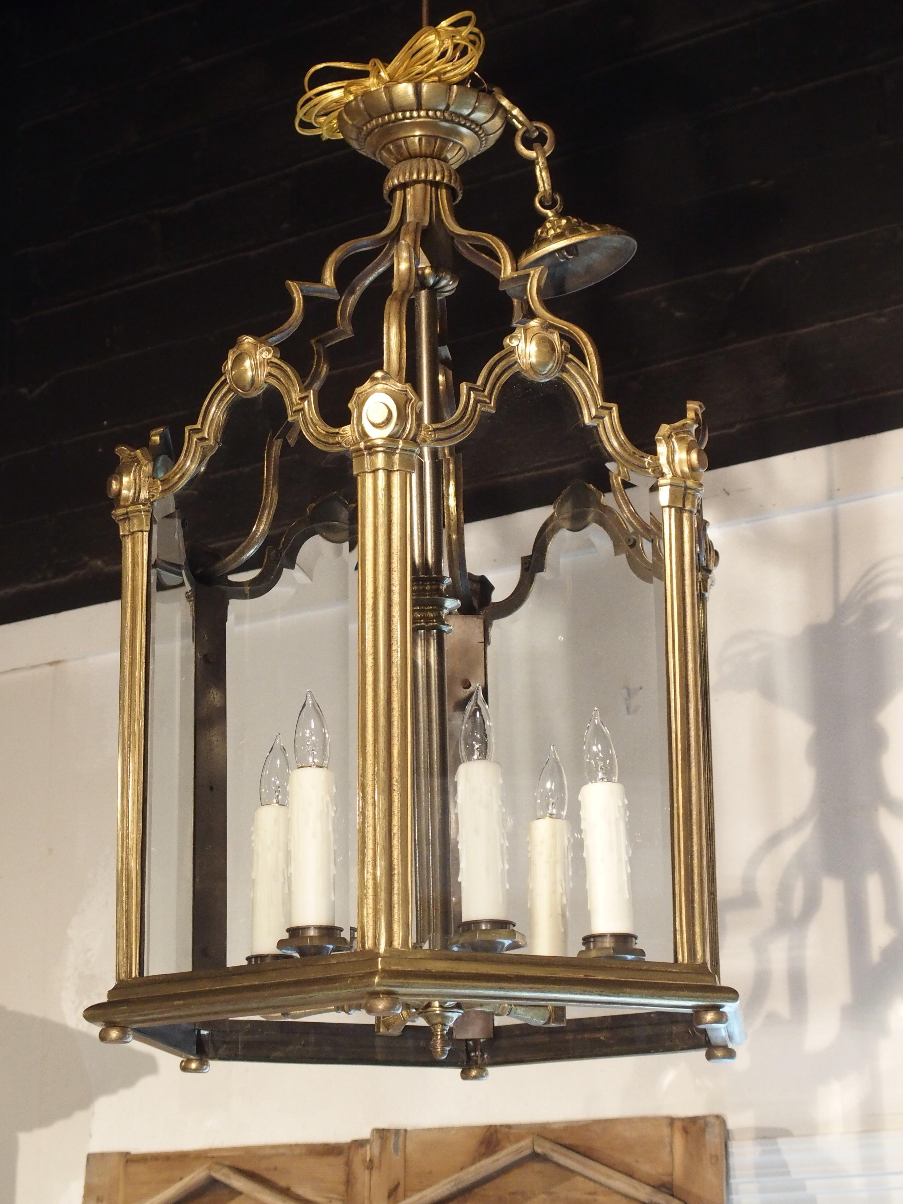 This elegant, large French bronze lantern was produced circa 1890 in the style of Louis XV. The glass panes have been arranged in a 25-inch diameter hexagon with a central cluster of six lights.

The top of the beveled-edge glass is shaped and