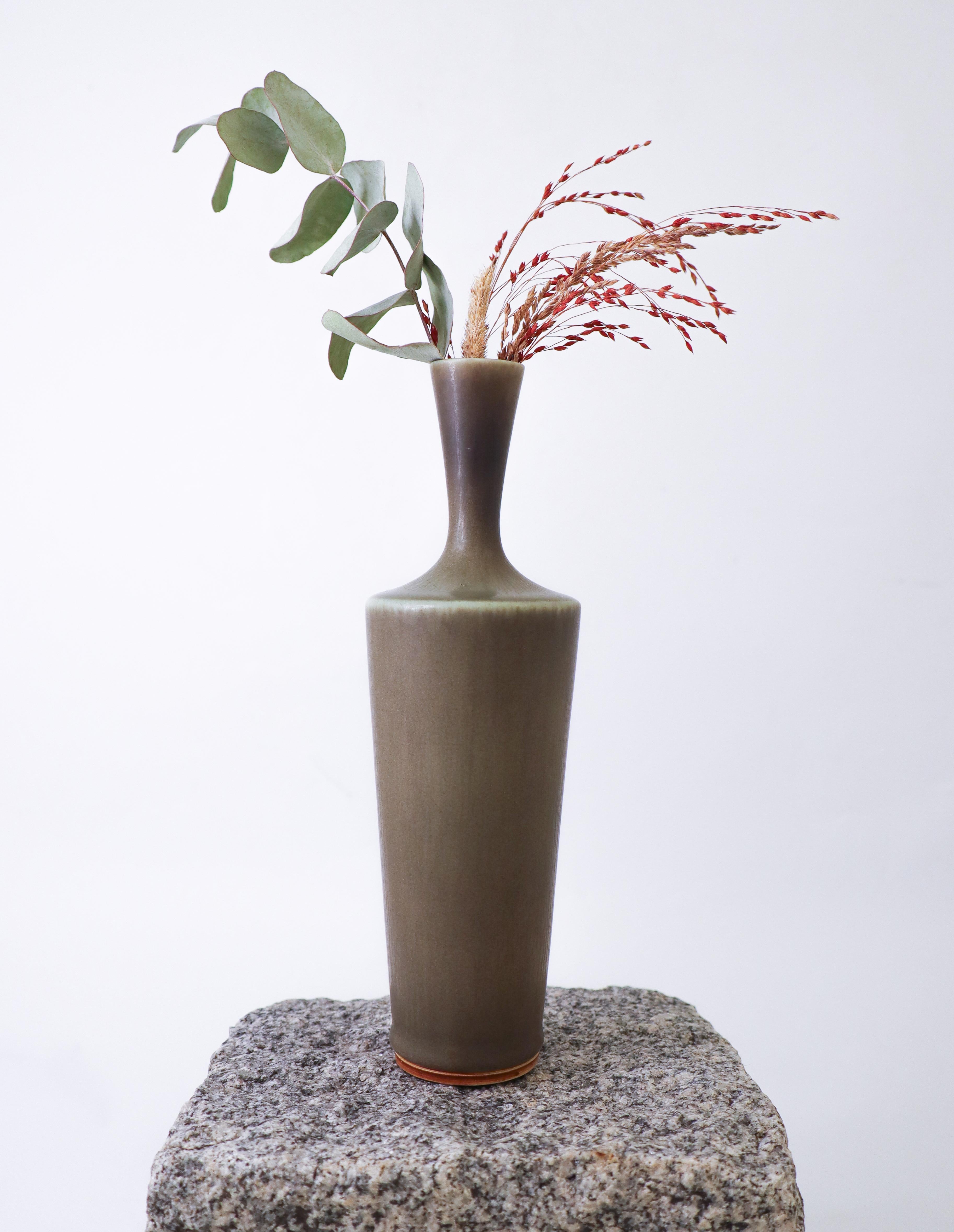 Vase en céramique gris/vert conçu par Berndt Friberg chez Gustavsberg à Stockholm. Le vase mesure 22 cm de haut et environ 7 cm de diamètre. Il est en très bon état et marqué d'un I+I indiquant qu'il a été produit en 1967. 