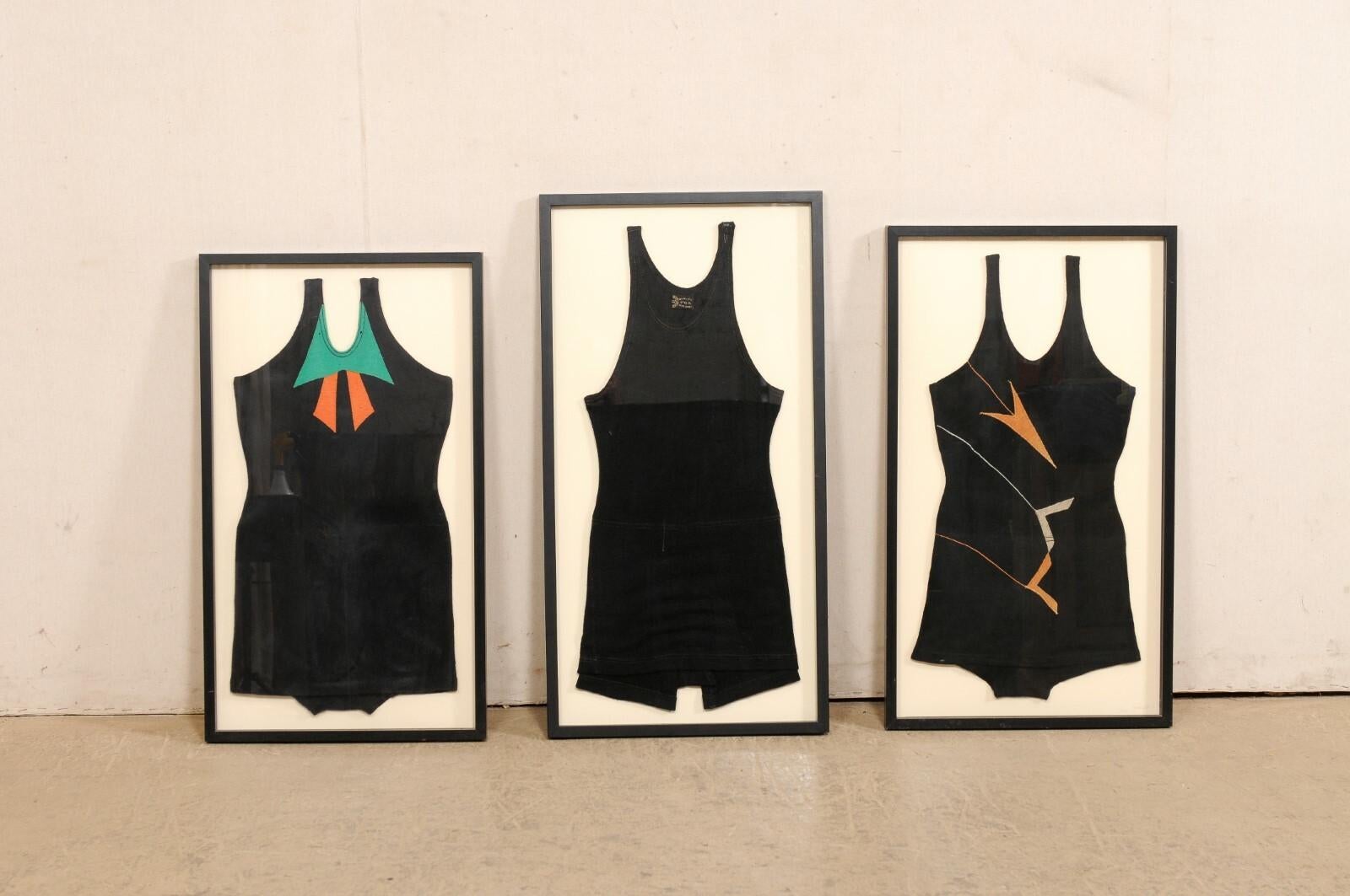 A set of three framed bathing suits from the 1920's. This collection of antique swimwear is comprised of two female swimsuits and a male suit which are beautifully displayed within sleek and contemporary black .75
