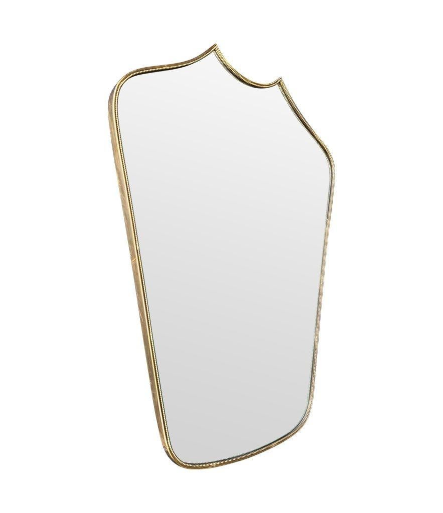 Brass A great shaped orignal Italian 1950s shield mirror with brass beaded frame