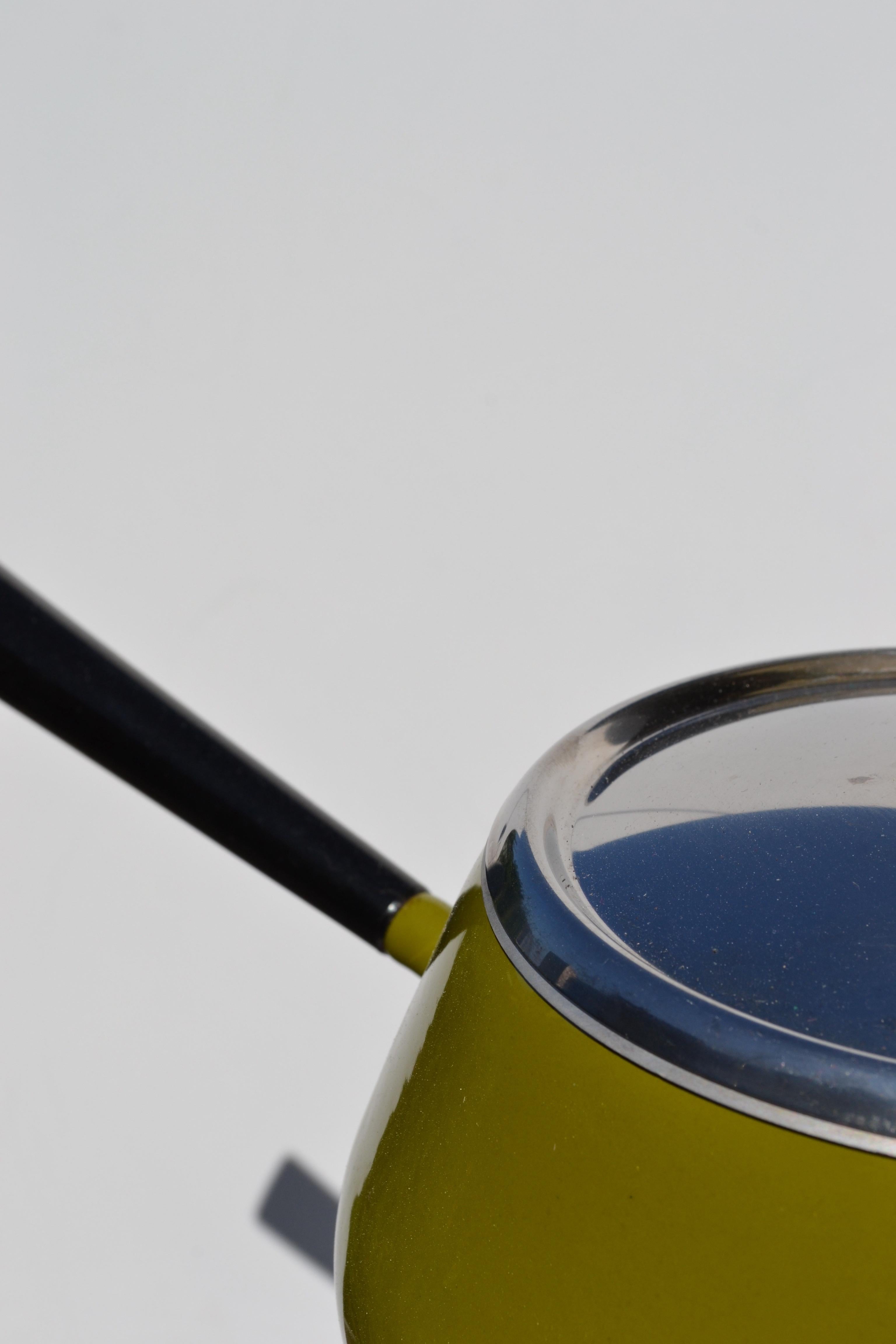 A beautifully preserved complete fondue set, crafted in Switzerland by the renowned brand Spring during the 1960s.
This rare model features a vibrant green enamel pot, an elegant chrome-plated stand, and its original burner — all in near-pristine