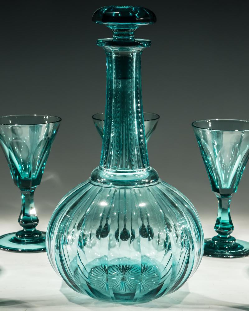 A Victorian green slice cut globe decanter with nitch cut neck and star cut in base with nine matching slice cut wine glasses. Attributed to Richardson of Stourbridge.

Glasses
Measures: Height: 13cm (5 1/4