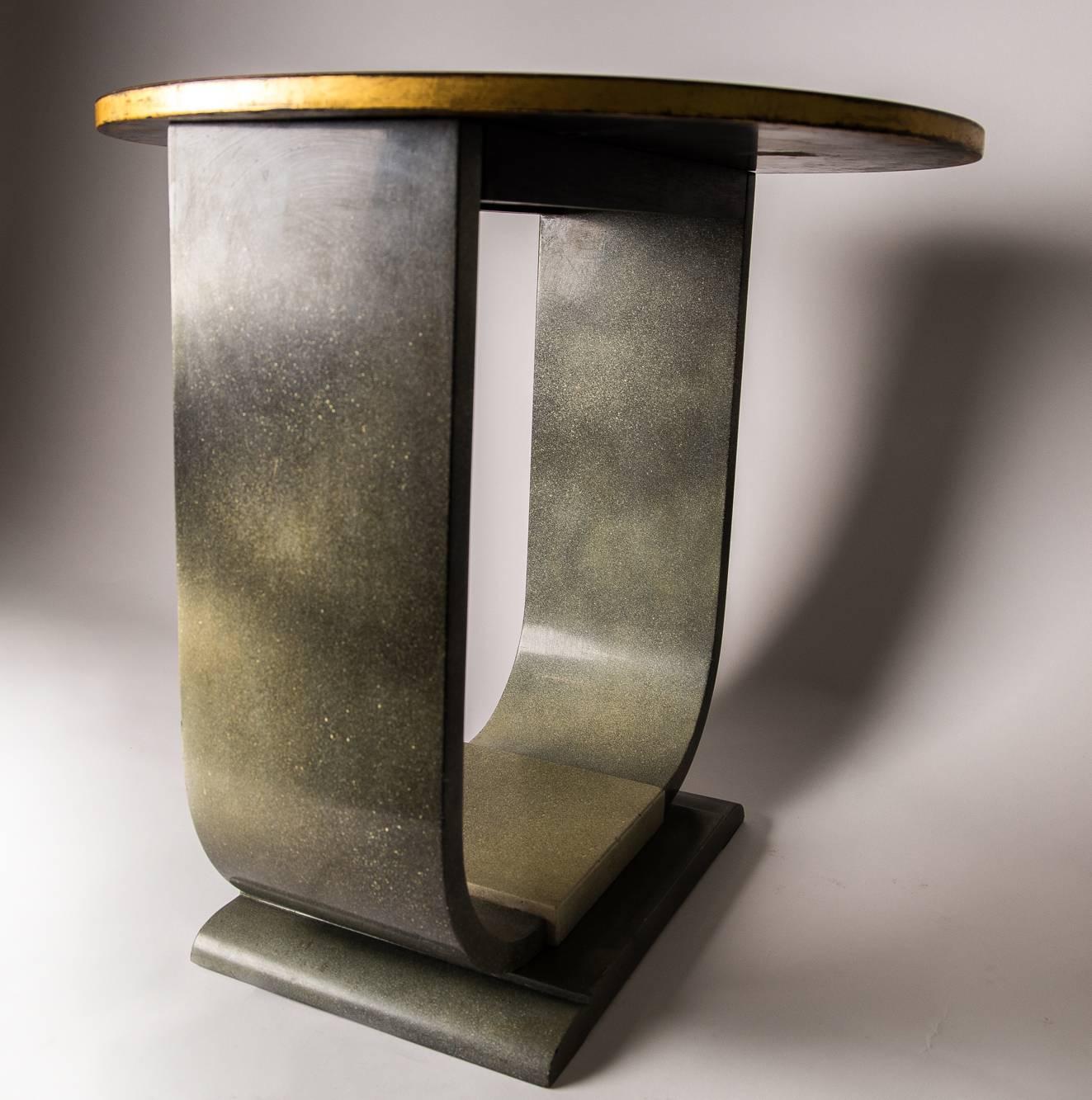 Lacquered in shades of blended green, featuring sculptural U shape design with round black lacquered top and gilt edging.
Terminating in an elegant pedestal style base.

  