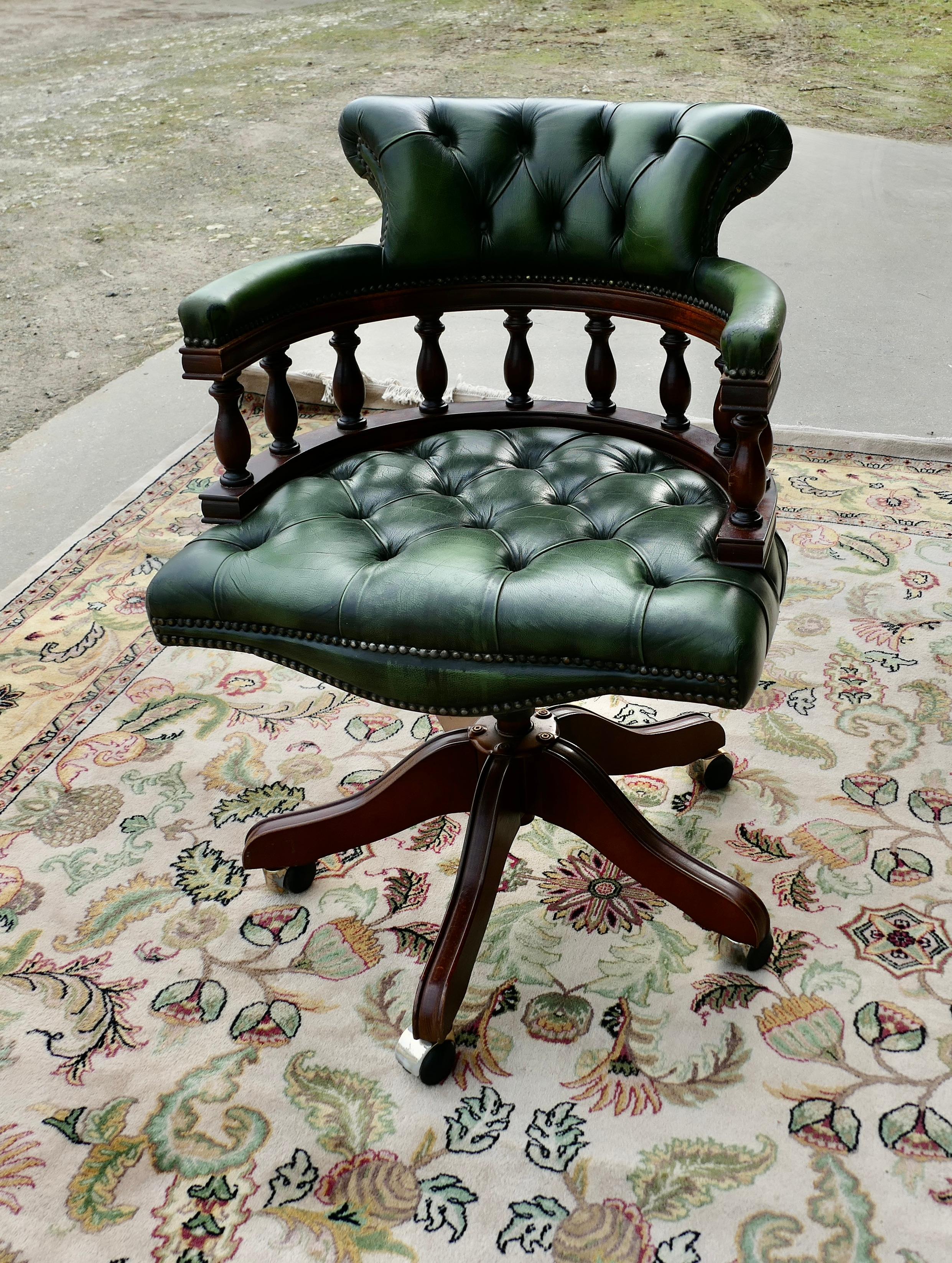  A Green Leather Swivelling Desk Chair or Captains Chair  

The Chair has an attractive high curving upholstered back top rail, the Chair Seat is deeply buttoned upholstered and very Comfortable, it rises, tilts and swivels
The back of the chair is