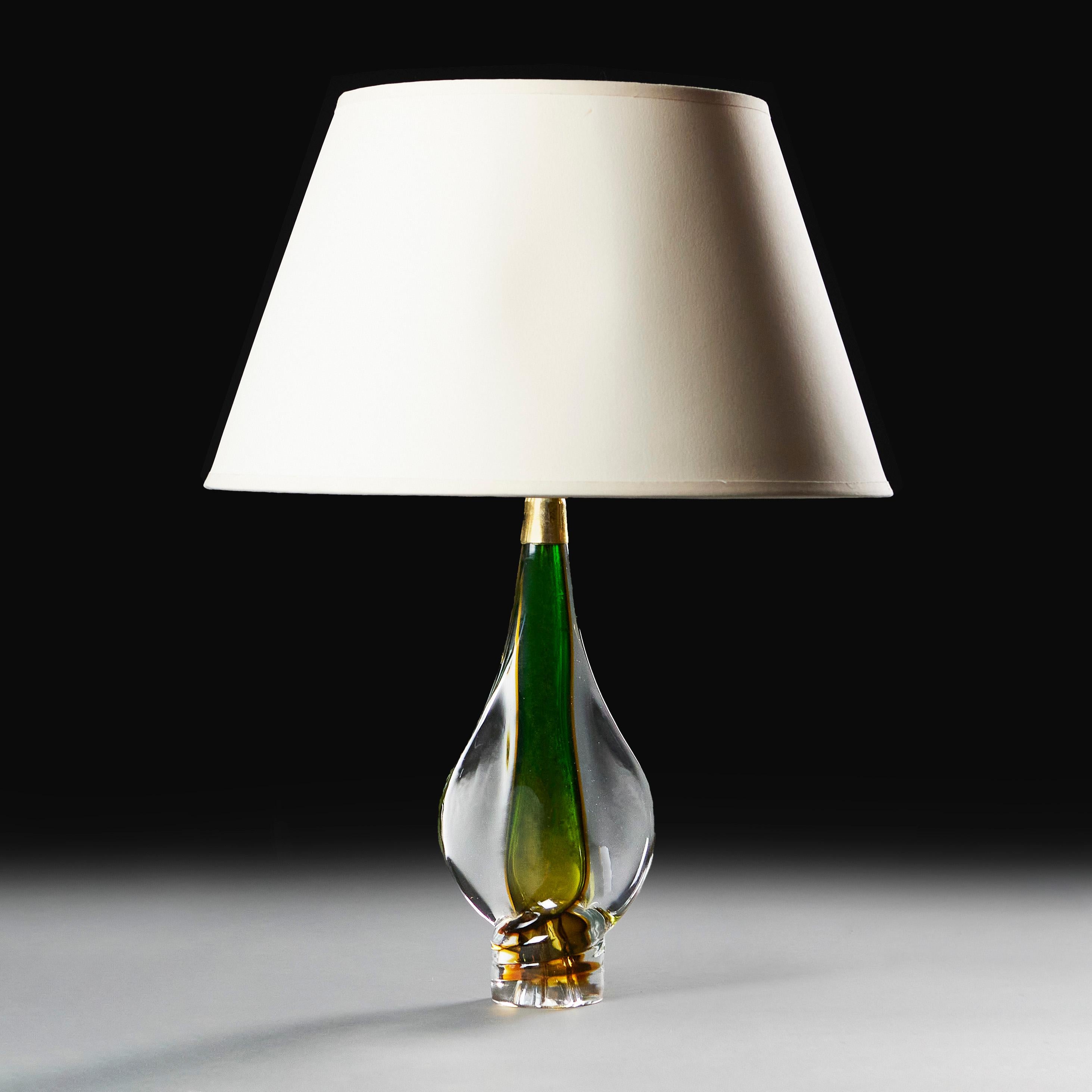 Italien, um 1940

Eine Lampe aus Murano-Glas mit grünem Zentrum, hergestellt in der für Murano typischen Sommerso-Technik, mit tropfenförmigem Körper und Messinghals.

Höhe der Lampe     36.00cm
Höhe mit Beschattung   61.00cm
Breite des Körpers  