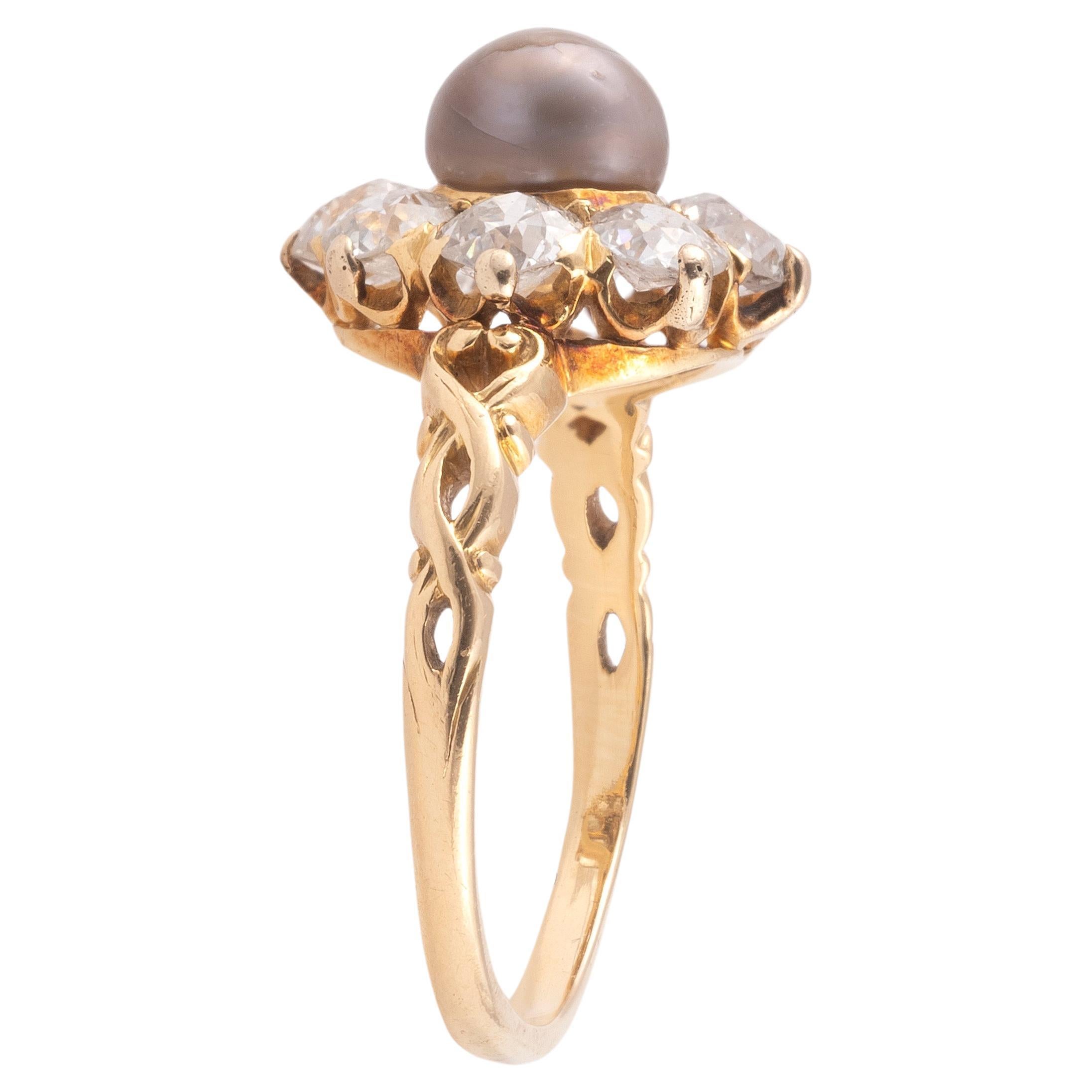 Ein Ring mit Perlen- und Diamantenbesatz.
Eine Perle, umgeben von acht kissenförmigen Diamanten mit altem Minenschliff in einem Cluster auf geschnitzten Schultern. Montiert in Gelbgold. Jeder Diamant hat ca. 0,10 Karat. Die Perle ist ca. 6 mm