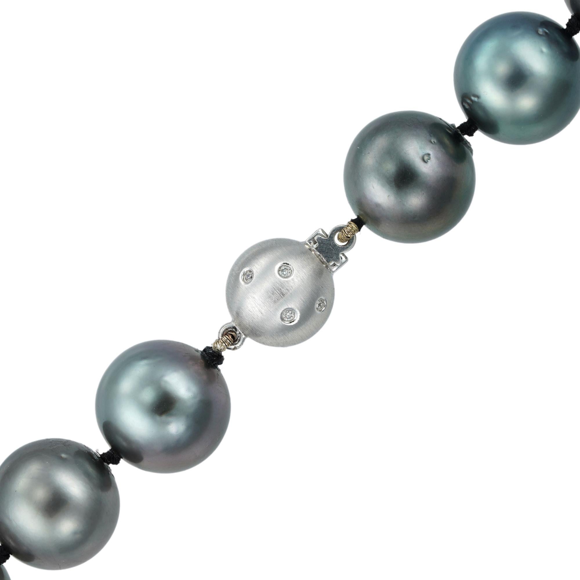 A graduated silver/grey Tahitian pearl necklace, the pearls graduating from  15.5mm to 12mm from the centre, double knotted and  fitted with a matte white gold ball clasp set with eight round brilliant cut diamonds of 0.04 carats in total, bearing