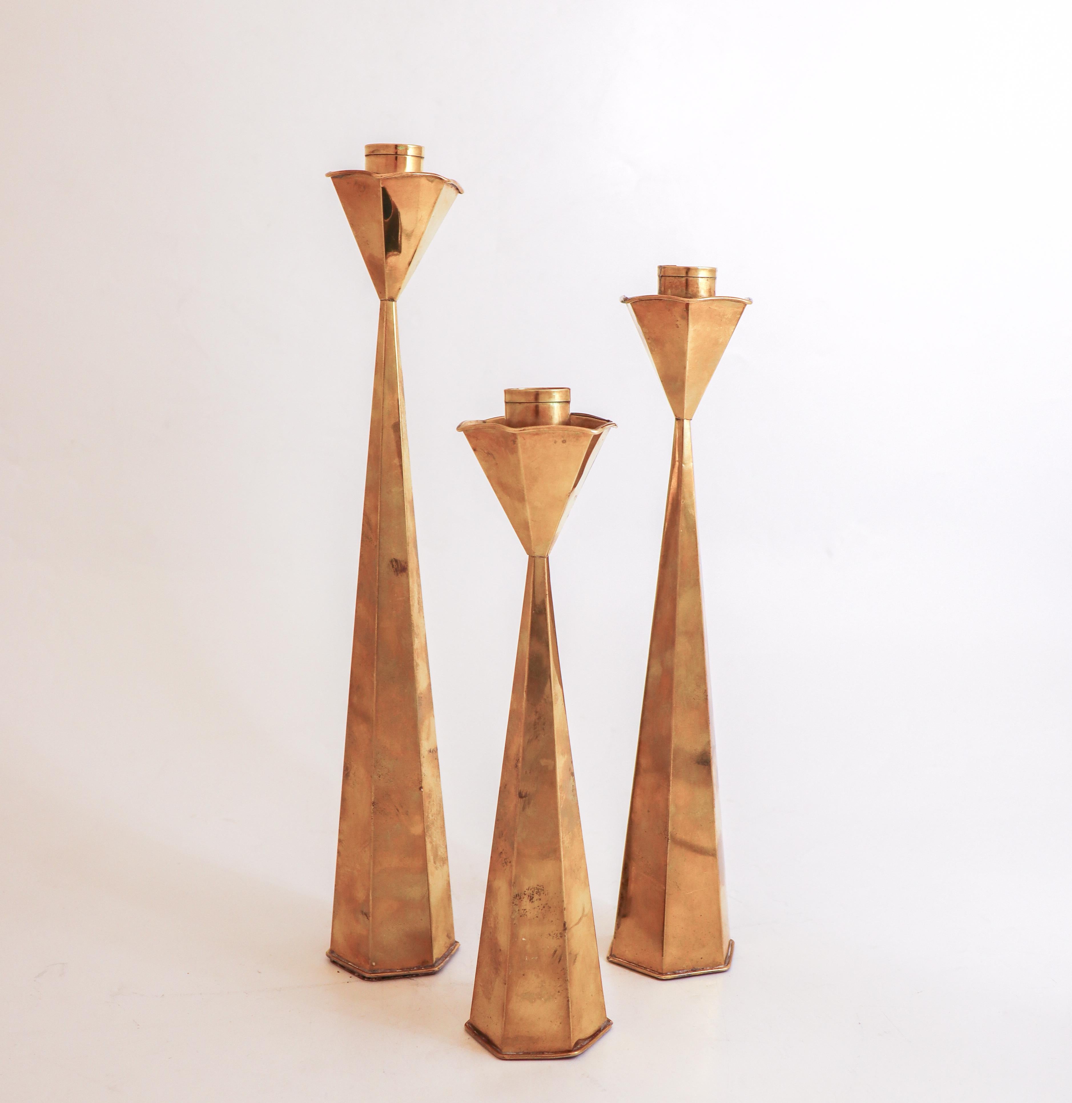 A group of 3 beautiful candlesticks in brass (not solid brass). They are between 23 - 31 cm tall and in excellent condition except from some marks and scratches, They’ve released slightly at the joints both at the top and bottom, but are fully