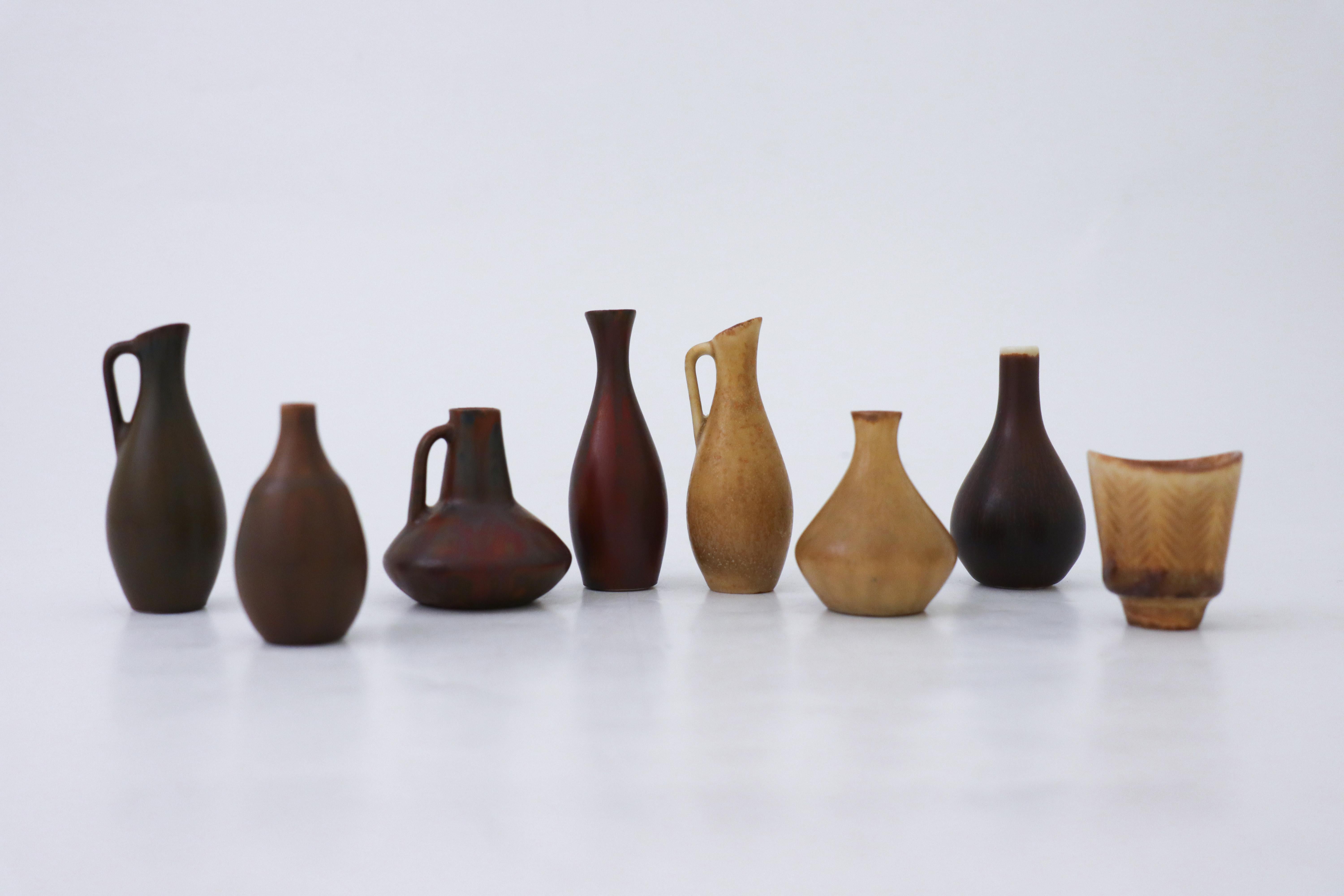 Eine Gruppe von acht Vasen, die meisten davon mit der charakteristischen Harfur-Glasur in verschiedenen Farben. Sie sind zwischen 7,5 und 4 cm hoch. Sie alle wurden von Carl-Harry Stålhane in Rörstrand, Schweden, entworfen. Sie sind in sehr gutem