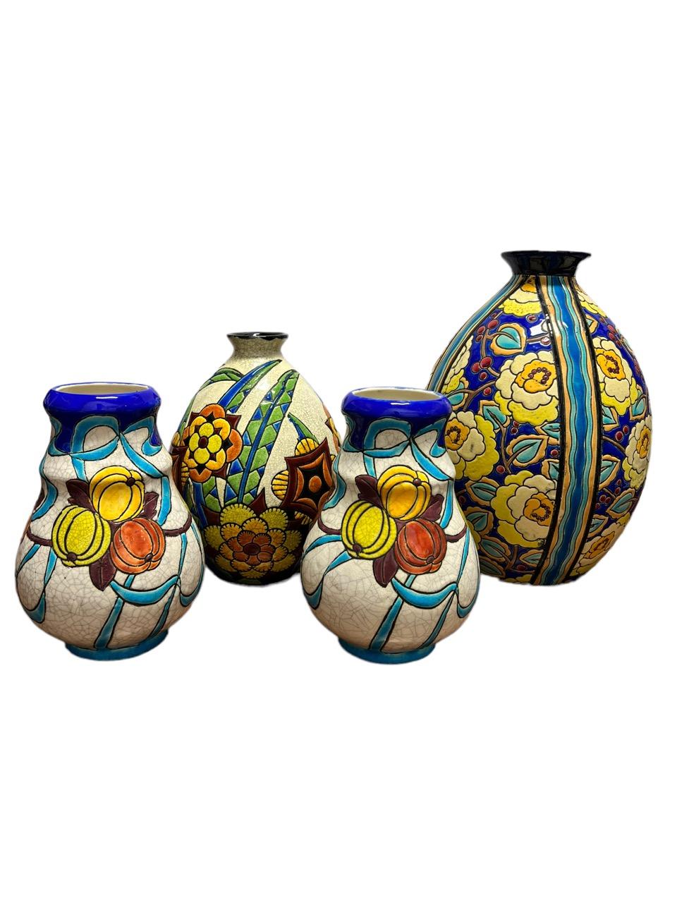 Presenting a captivating quartet of 1920s floral vases, masterfully crafted by the renowned artist Charles Catteau (1880-1966) in glazed earthenware. Each of these exquisite vases bears its own unique number and is adorned with markings, some