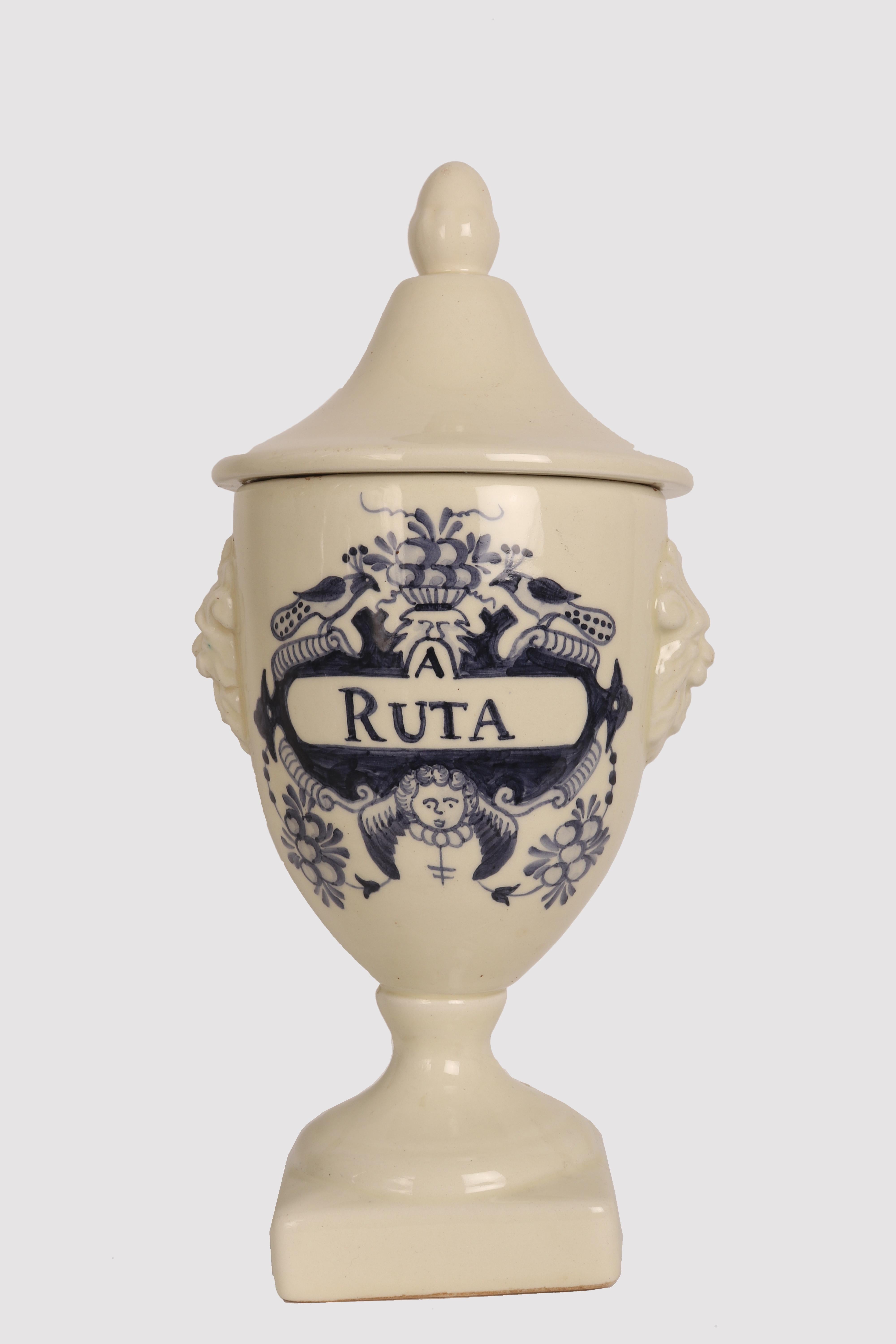 Set of four large white ceramic apothecary-herbalist jars with cobalt blue decorations, to contain Rue, Castor, Mallow, Thistle in a neoclassical style. The handle of the lid is in the shape of an acorn, on the sides of the vase there are two