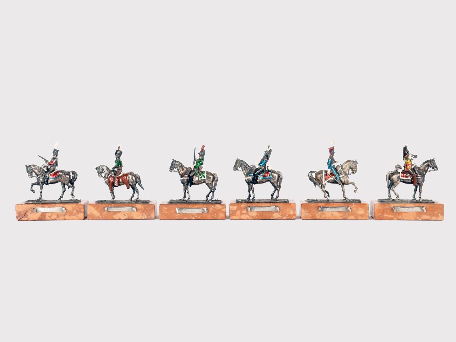 Il gruppo di 6 sculture è realizzato in argento 800/1000, smalto e base in marmo rosso di Verona. La base è rettangolare, si alza perpendicolarmente e ha gli angoli arrotondati. Lungo il lato della base un cartiglio ospita la descrizione relativa