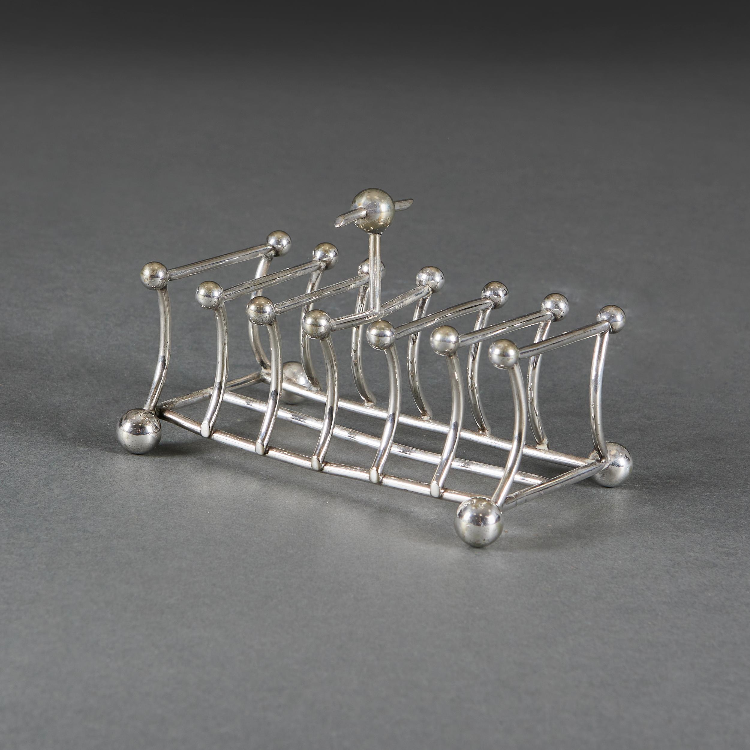A group of three silver plated toast toast racks in the manner of Christopher Dresser, two of triangular form, all three with ball feet.
