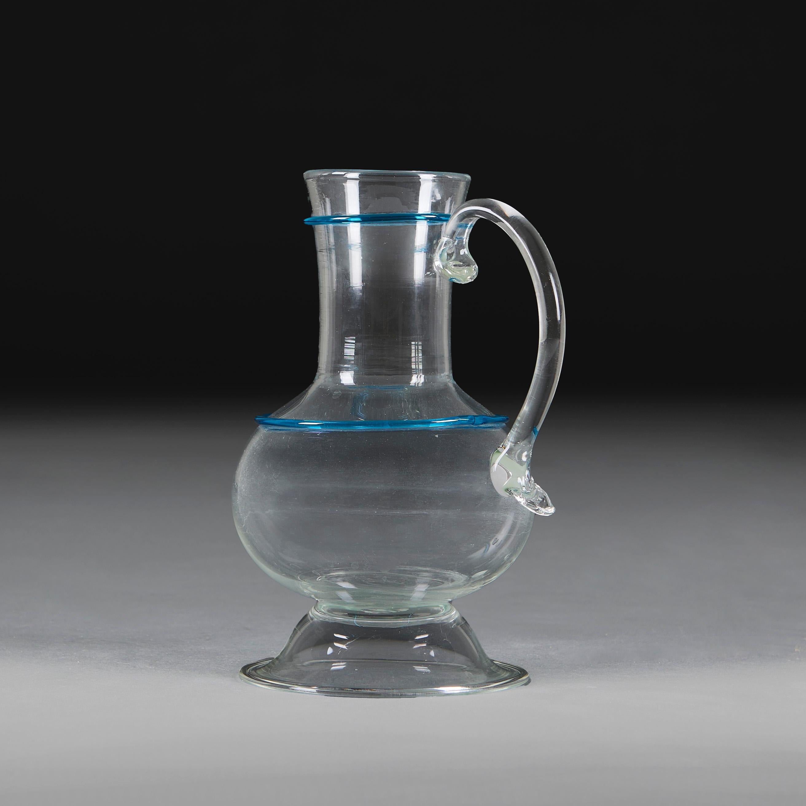 Eine Gruppe von drei Murano-Glaskrügen aus der Mitte des zwanzigsten Jahrhunderts, mit blauem Schleuderglas auf den Körpern und den Hälsen, mit geschwungenem Henkel auf einer Seite.