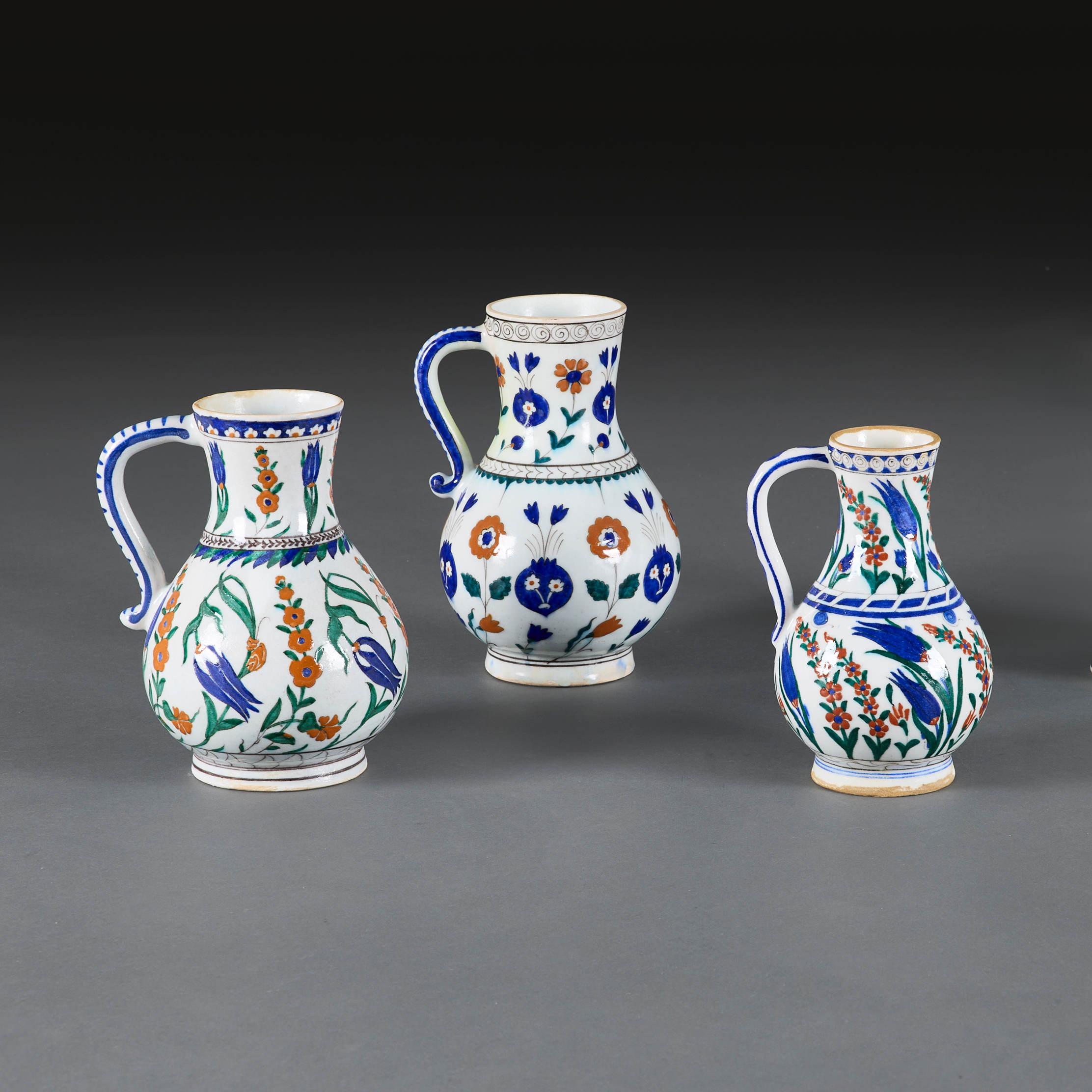 Turquie et France, vers 1890 et après.

Un groupe inhabituel de quatre cruches d'Iznik avec des pulvérisations florales polychromes typiques de tulipes, de rosettes, d'œillets et de feuilles de saz. L'un d'entre eux provient de l'entreprise