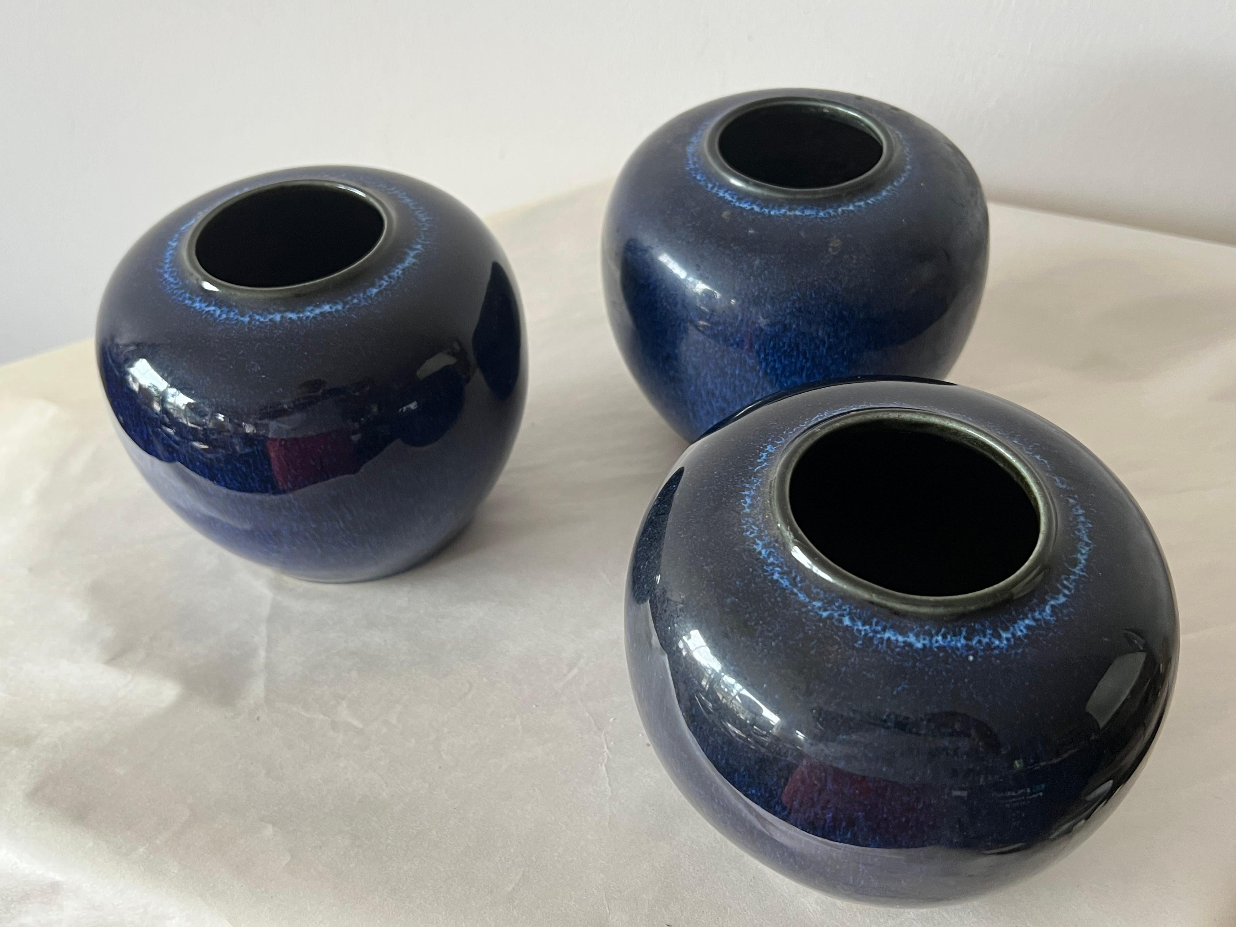 Un ensemble intéressant de trois vases bleu cobalt, mouchetés, du Japon. Vers les années 1950. Haute glaçure, avec des tons bleus profonds. Estampillé sur le fond - Japon.