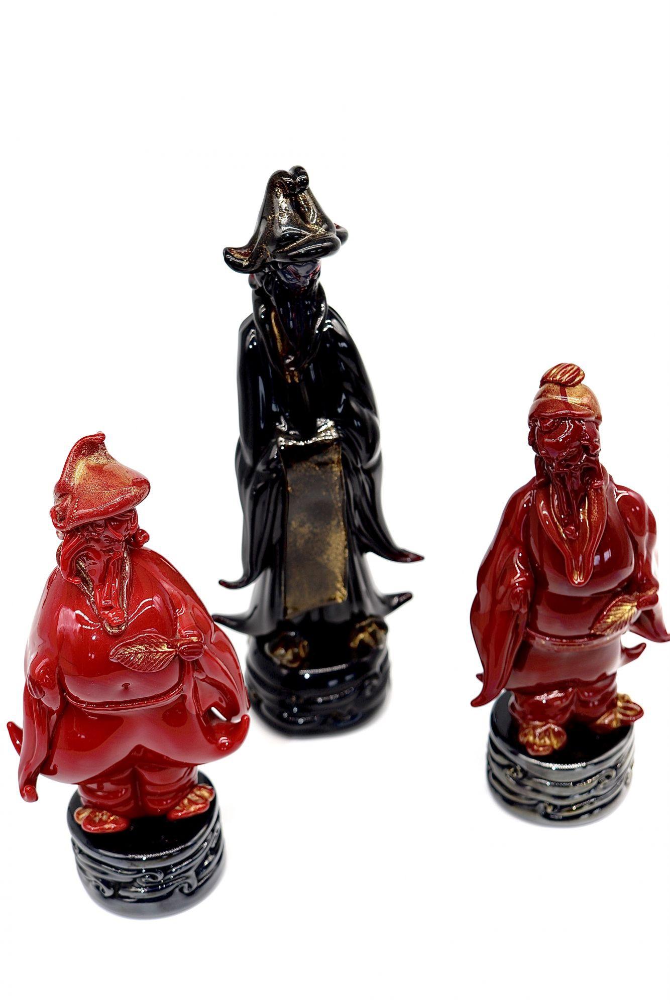 Italian (Venetian) Group of 3 rare, incredibly detailed and refined Oriental figurines, 3 males one in coral pasta glass, another in burgundy glass and the third in black glass. Standing on a black round bases with wave motif, they are perfect in