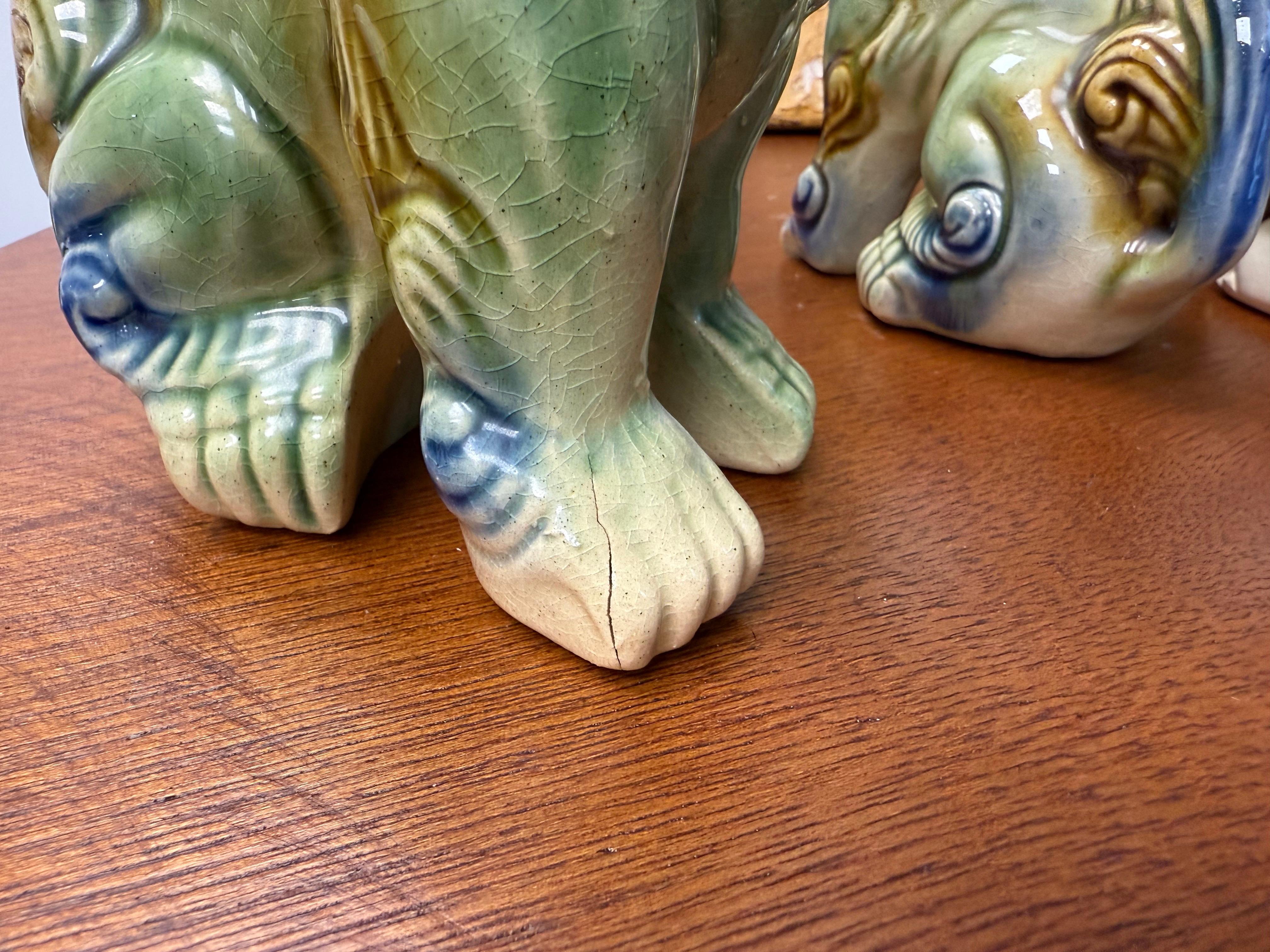 Great grouping of  four mid-century polychrome glazed ceramic foo dogs, circa 1960s. Great detail and a beautiful color combination of green, brown, cream and blue

The largest measures: 7.25” tall x 4” wide x 6” deep
The smallest measures: 5.5”