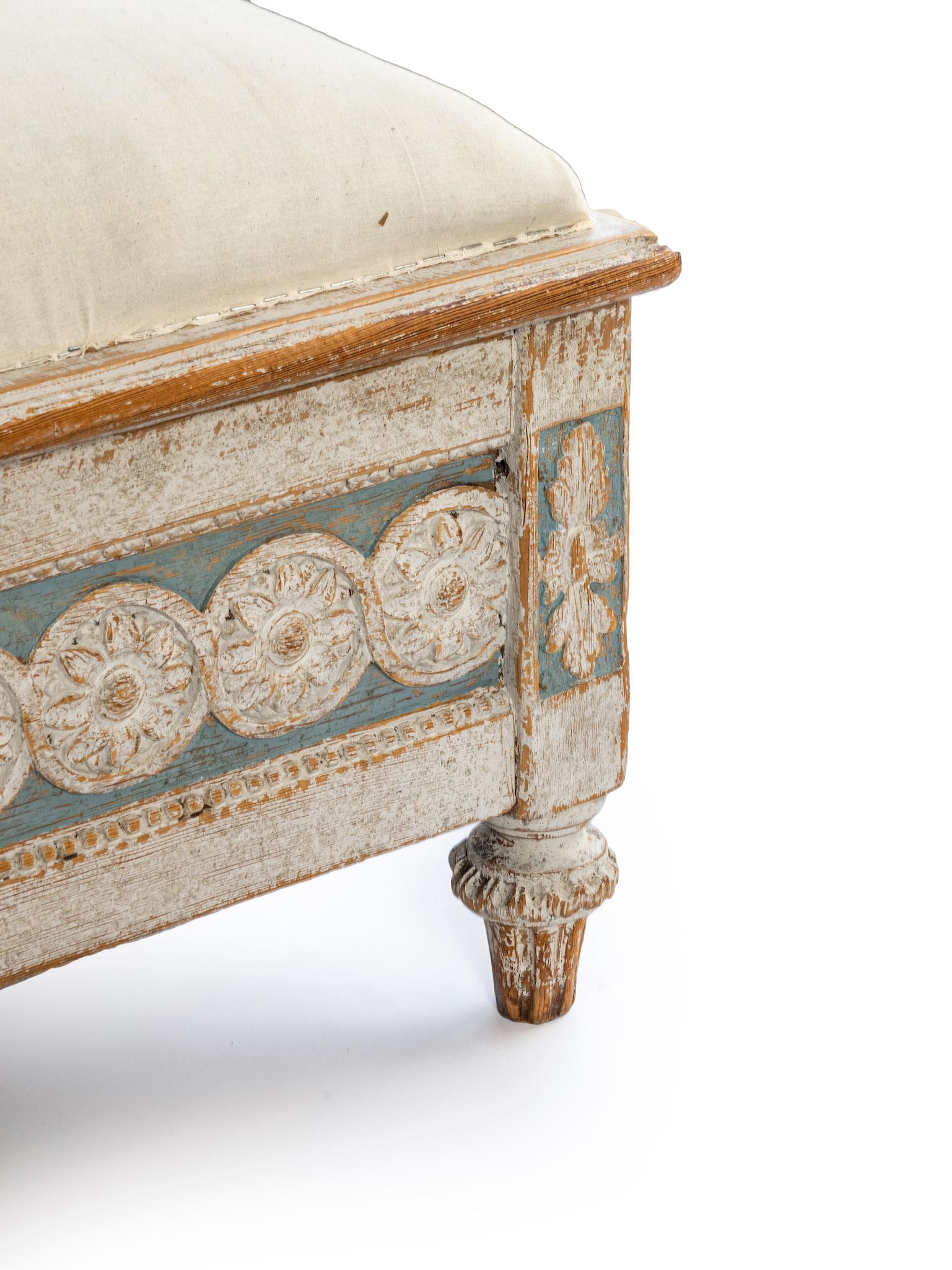 A period Gustavian bench in blue and light grey.