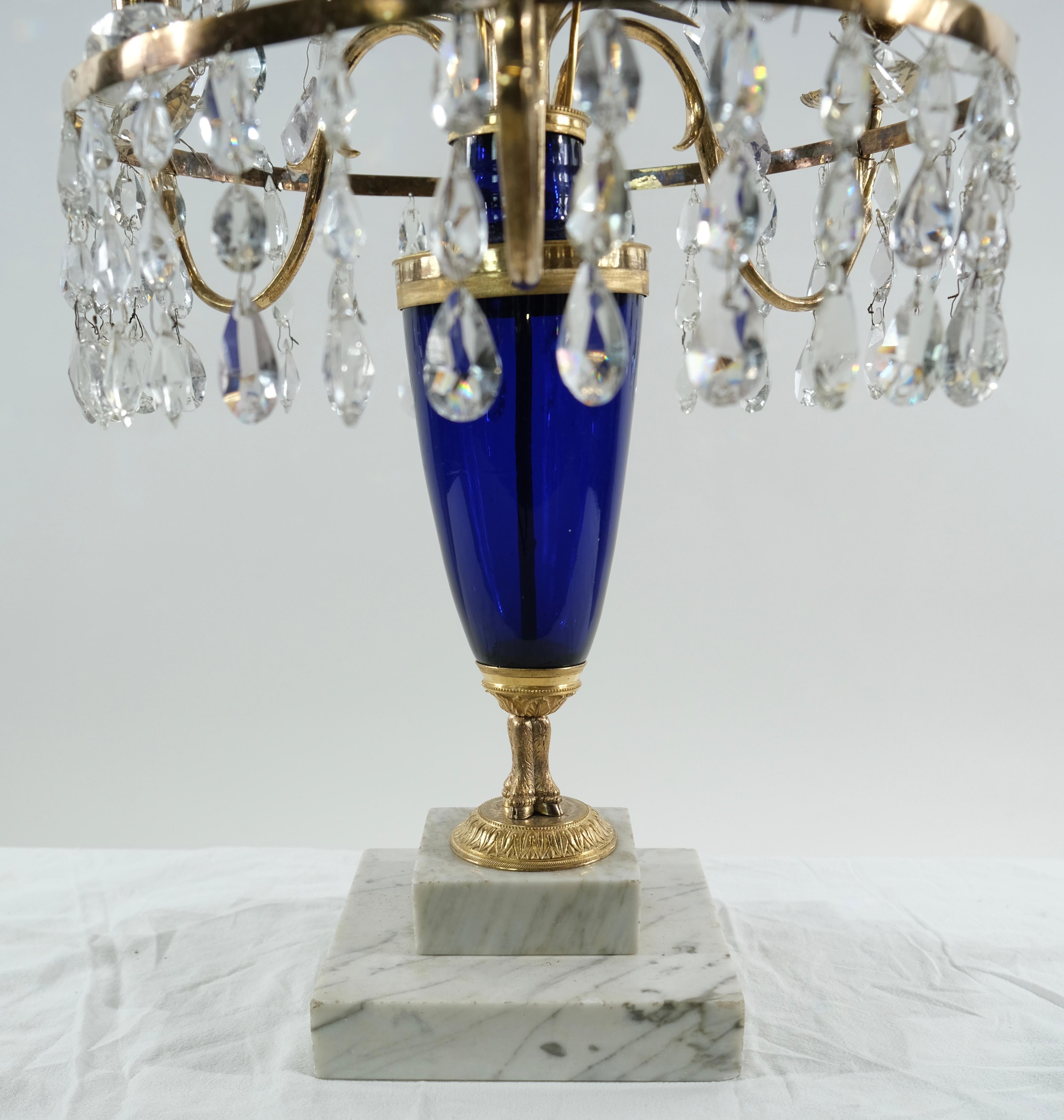 A Swedish Gustavian candelabrum. It is designed with a cobalt blue blown glass. This type of glass was the most expensive in the 18th c and these type of objects were really expensive. The candelabrum has a base of marble on which a crystal obelisk