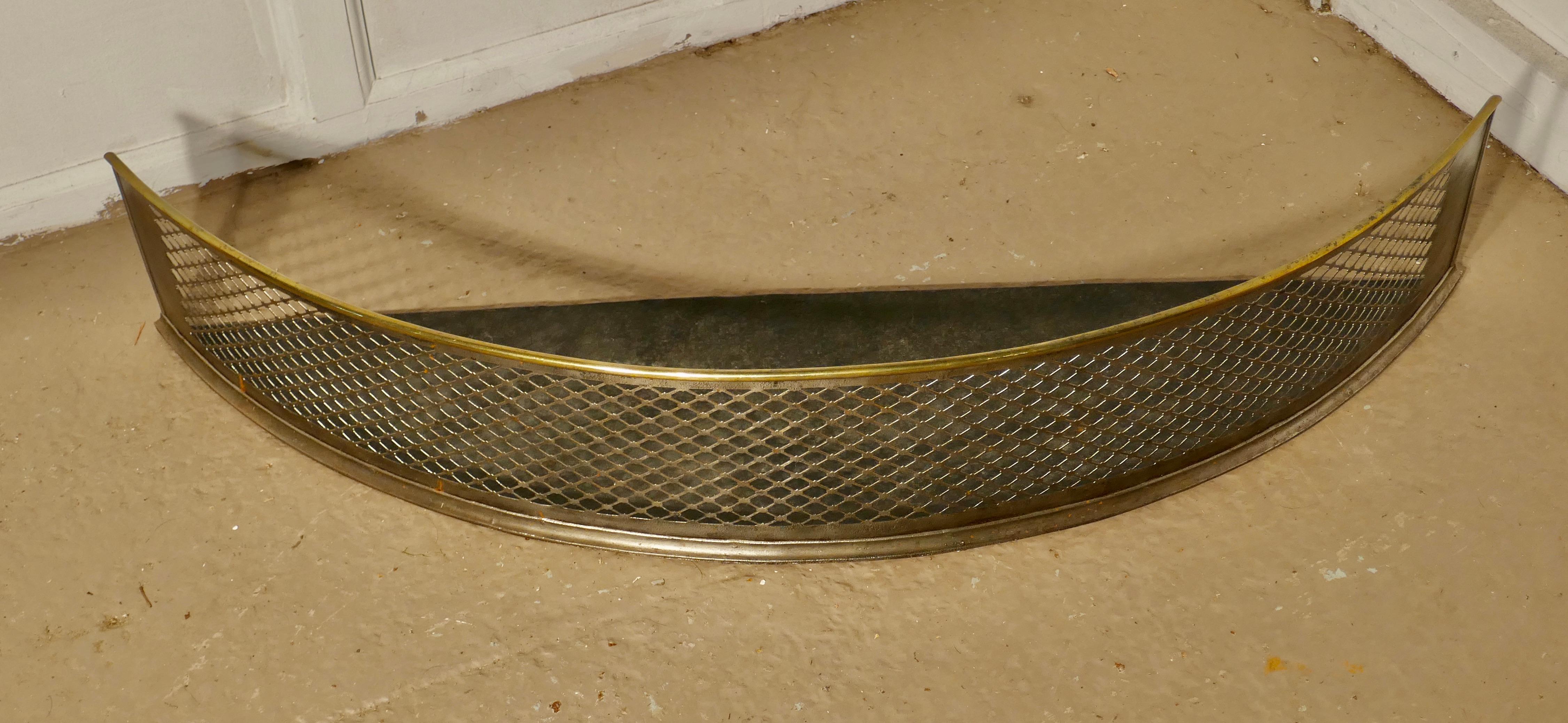 A half moon curved Victorian brass and iron fender 

This is a Victorian antique fender unusually this one is crescent shaped, the fender has a metal mesh spark guard with attractive brass rails top and bottom 
The fender is in very good all