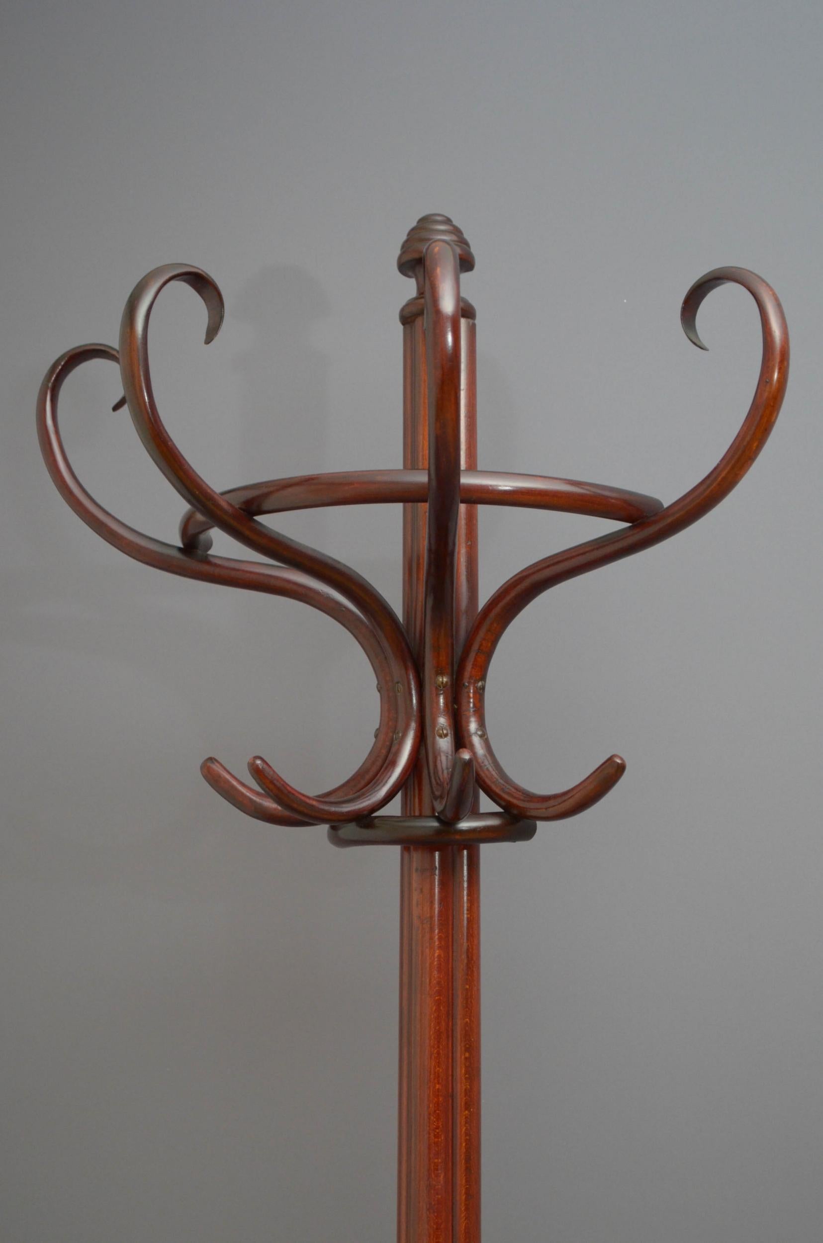 Sn5077 A half round bentwood hat stand, having four coat hooks and four bentwood scrolls for hats, surmounted by a beehive finial, supported on cluster column terminating in three downswept legs with a ring for sticks and umbrellas. All in fantastic