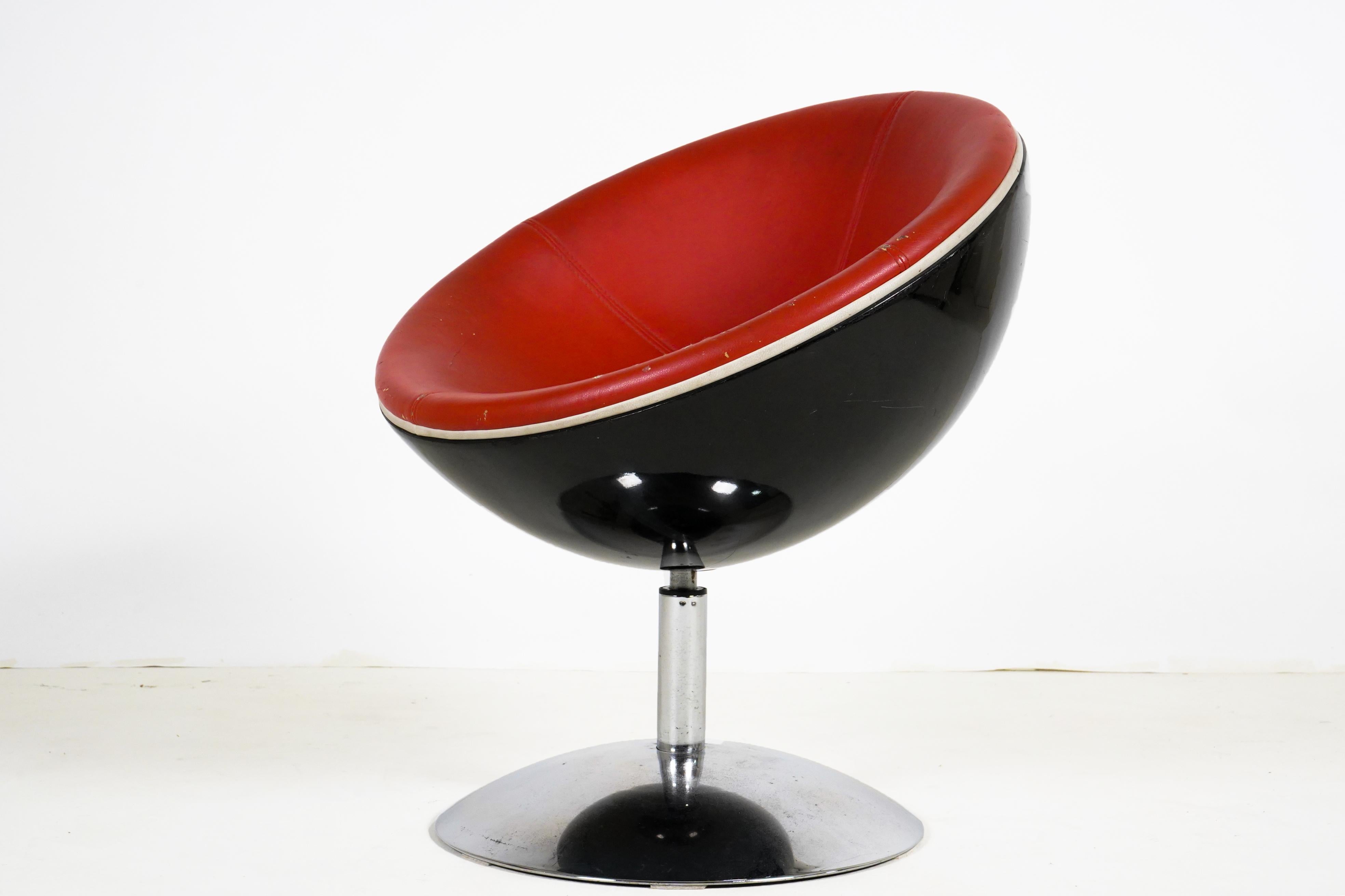 This playful 1970s pod chair swivels on a polished chrome base. The back of the pod is made from resin and the seating surface is soft synthetic leather. The leather is in overall good condition with no tears but there is some abrasion and loss of