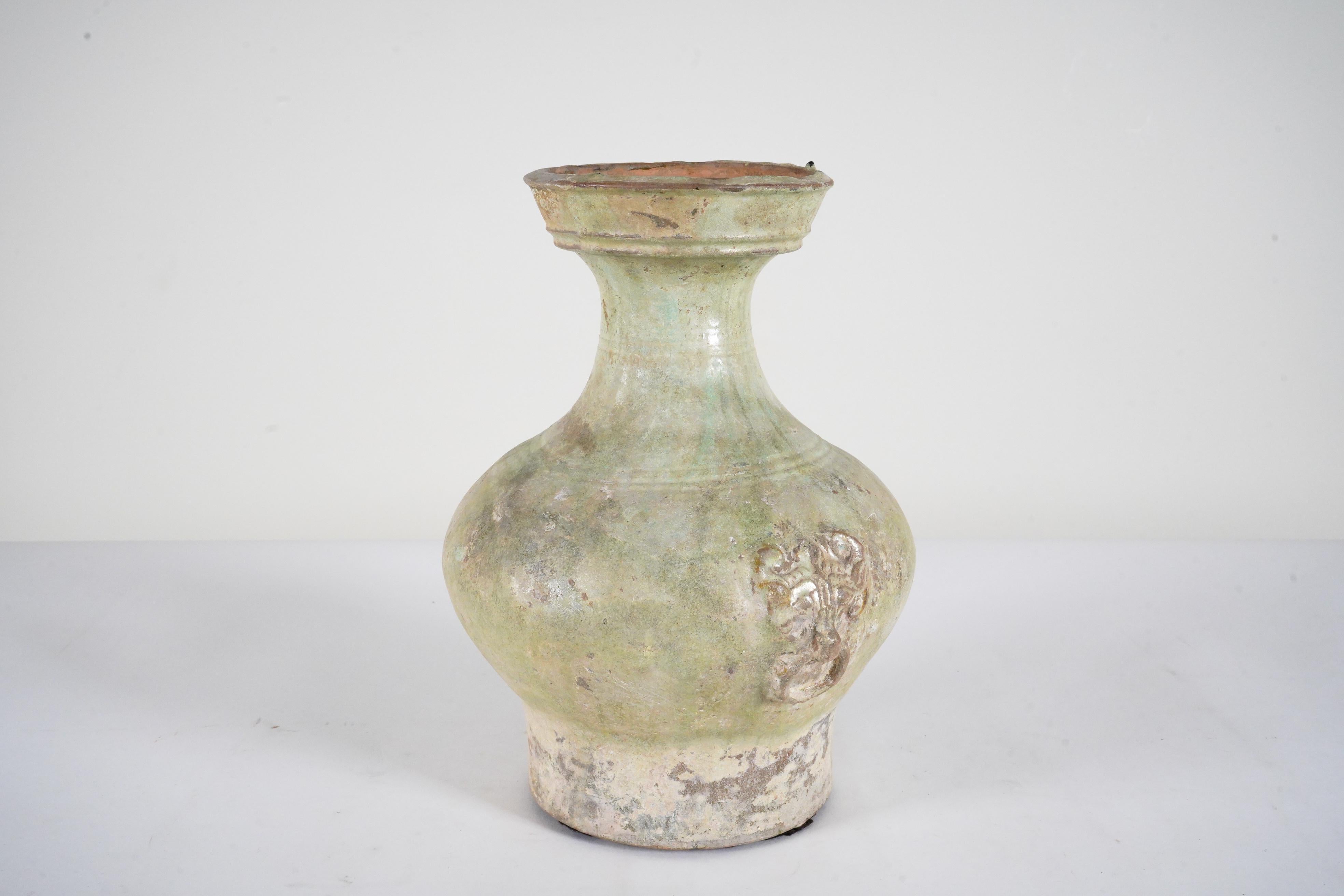 This is a fine, heavily patinated example of a Han hu wine storage vessel, buried for the afterlife. The compressed globular body narrows to a slender waisted neck, covered with a dark green lead glaze that has developed a silvery patina due to