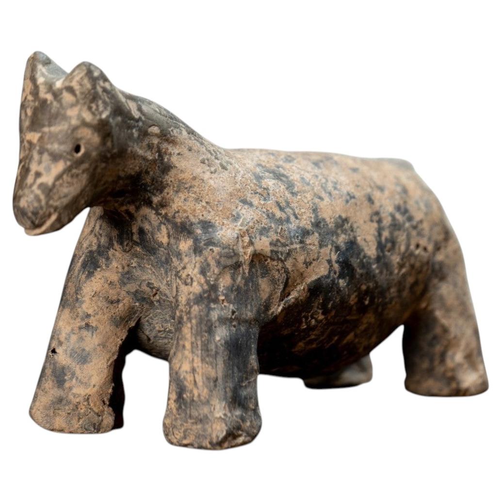 Une figurine en terre cuite représentant une vache, datant de la dynastie Han