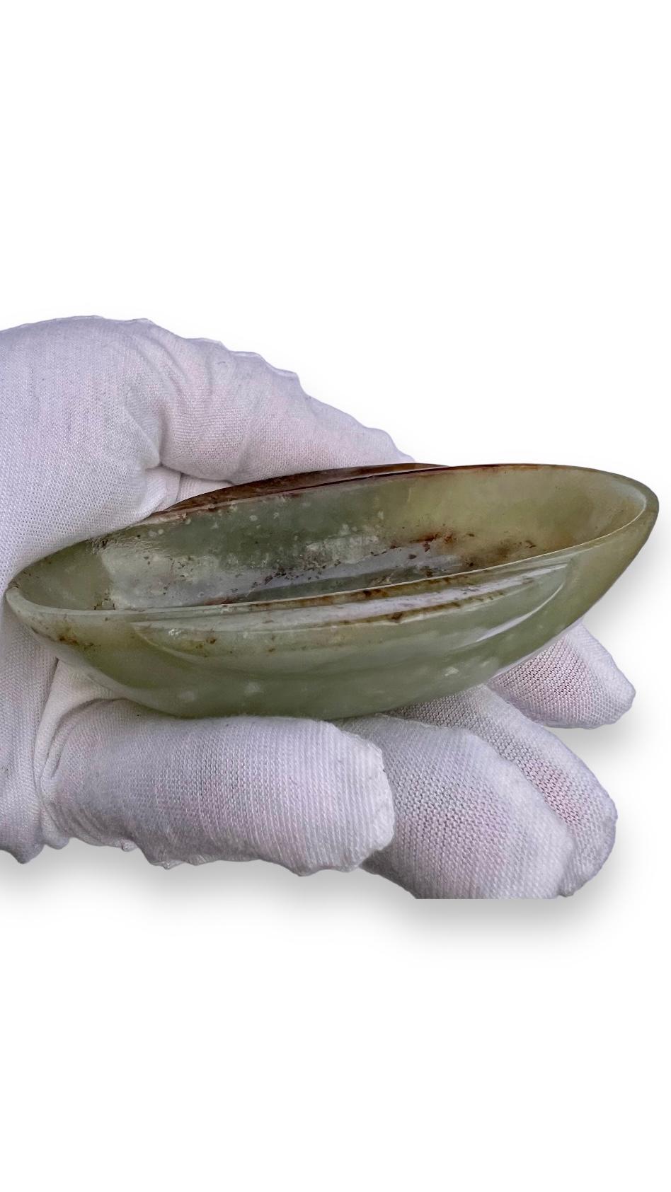 

A Han-style celadon and russet jade ear-cup.


Qing dynasty


of archaistic form, the shallow oval-shaped bowl with sturdy sides rising from a flat foot, the main sides flanked by a pair of elongated 'C'-shaped 'ear' handles extending just below