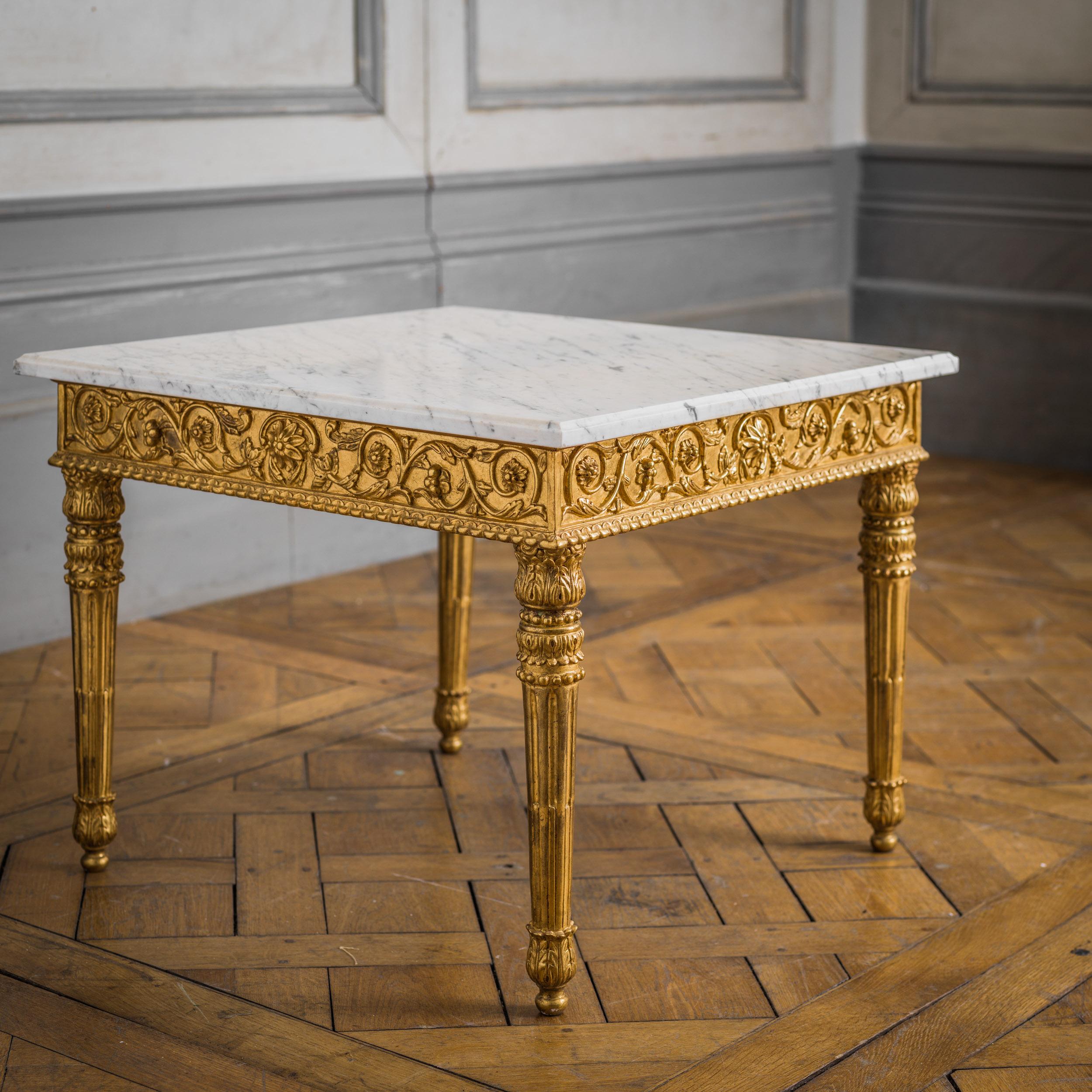 Una mesa de centro de estilo Luis XVI bellamente elaborada y tallada a mano, con finos detalles. Acabado en una pátina envejecida y dorada a mano, con una encimera biselada de mármol de Carrara. Otros tamaños disponibles. Fabricado por maestros del