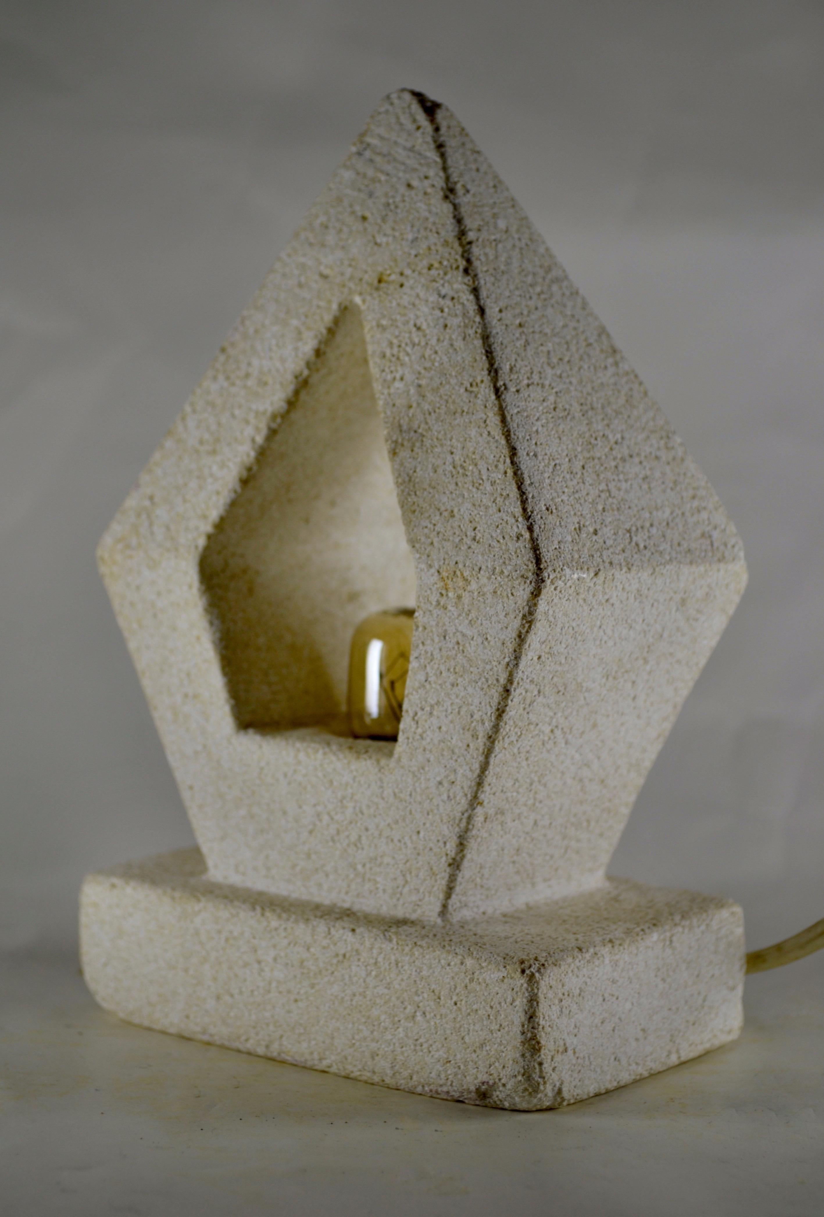 Una lampada in pietra calcarea intagliata a mano a forma di prisma, che mette in mostra l'artigianato francese degli anni '70 e riflette lo stile di Albert Tormos. Questo pezzo unico emette una luce calda e invitante, mettendo in risalto la bellezza