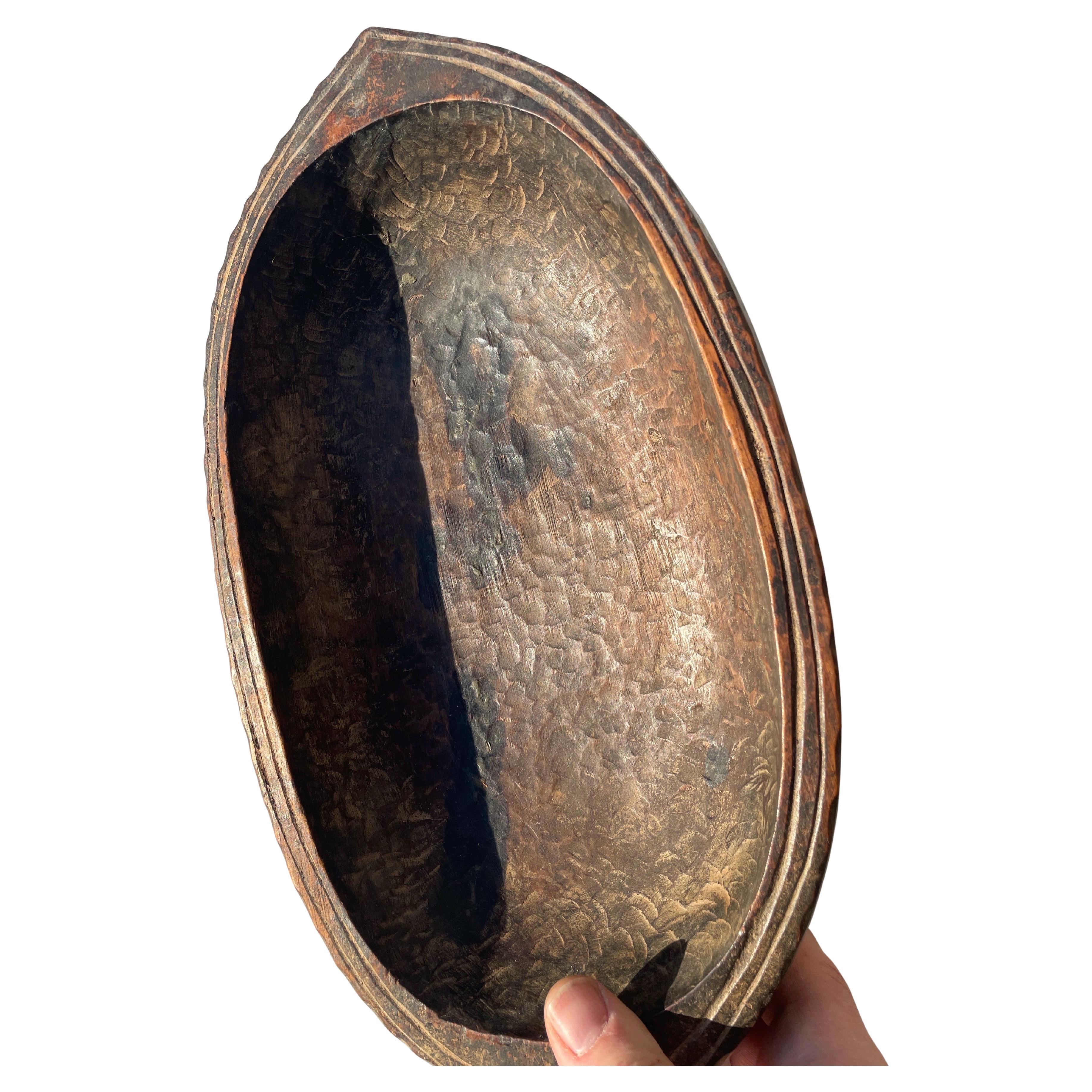 Ein wunderschöner handgeschnitzter Auffangbehälter aus einem einzigen Stück gealterten Holzes. Die Oberfläche zeigt ausdrucksstarke Schnitzspuren und eine reiche, von der Zeit gezeichnete Patina. 

Natürliche Abnutzungserscheinungen und alte