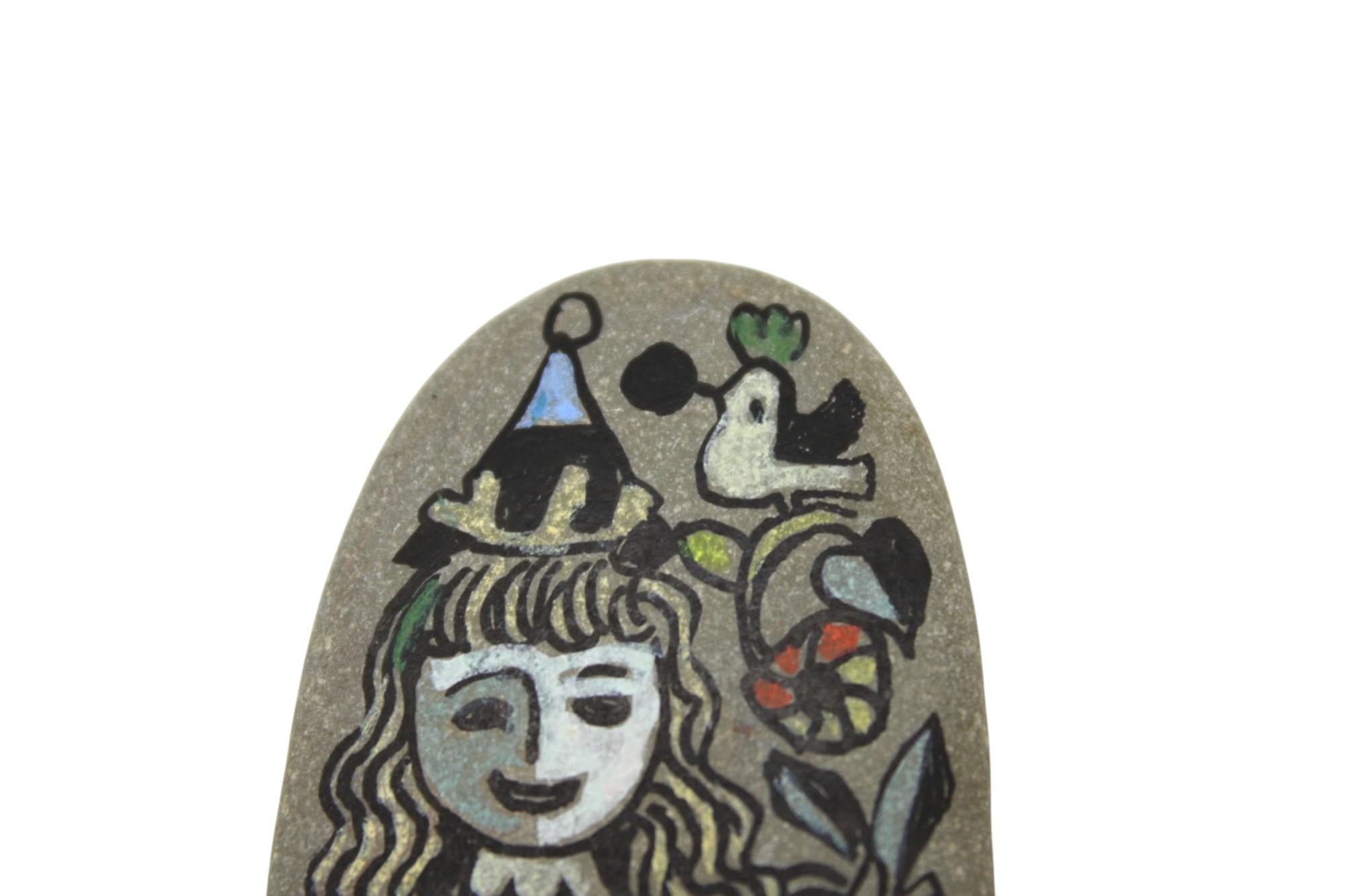 Esta encantadora piedra pintada a mano por Ilya Schor es una cautivadora celebración de la alegría, la fiesta y el arte popular. Firmada en el reverso por el artista y marcada con su lugar de creación en Provincetown, Massachusetts, esta pieza única