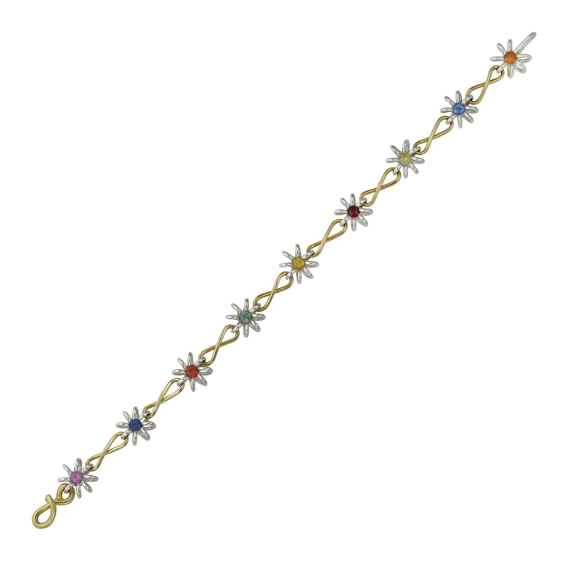 A handmade silver and gold bracelet by Lucie Heskett-Brem the Goldweaver of Lucerne, inspired by Darcey Bussell, the necklace consisting of nine silver flower-heads each centrally-set with a fancy colour sapphire, the sapphires estimated to weigh