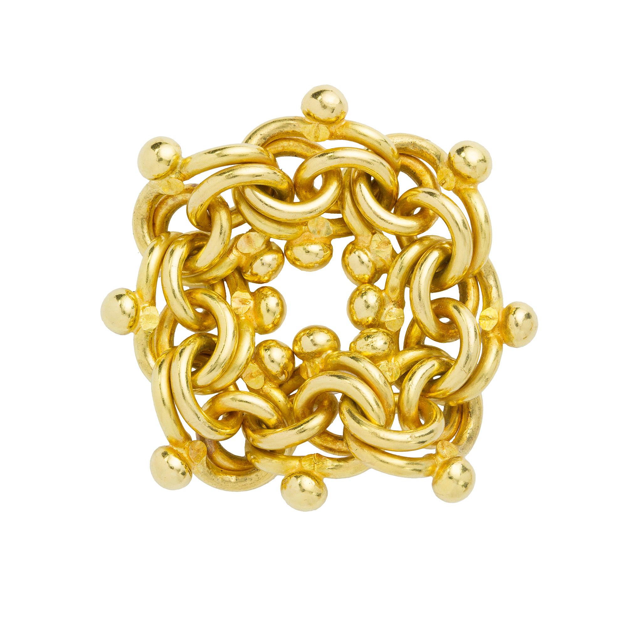 A handmade Troubadour gold ring by Lucie Heskett-Brem the Gold Weaver of Lucerne, the ring comprised of twelve interlocking links of a troubadour design with bead decoration, made in 18ct gold, finger size N, gross weight 18.5 grams.

This