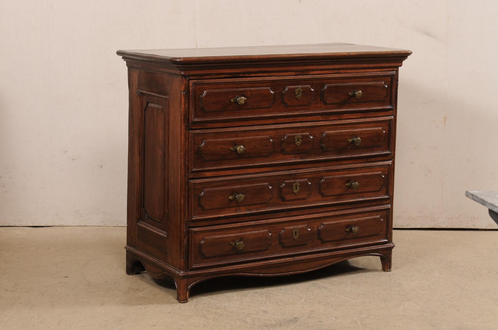 Commode italienne en noyer sculpté du XVIIIe siècle. Cette antique cassettiera (commode) italienne présente un plateau rectangulaire aux angles arrondis, un corps supérieur abritant quatre tiroirs gradués, des côtés à panneaux surélevés et une