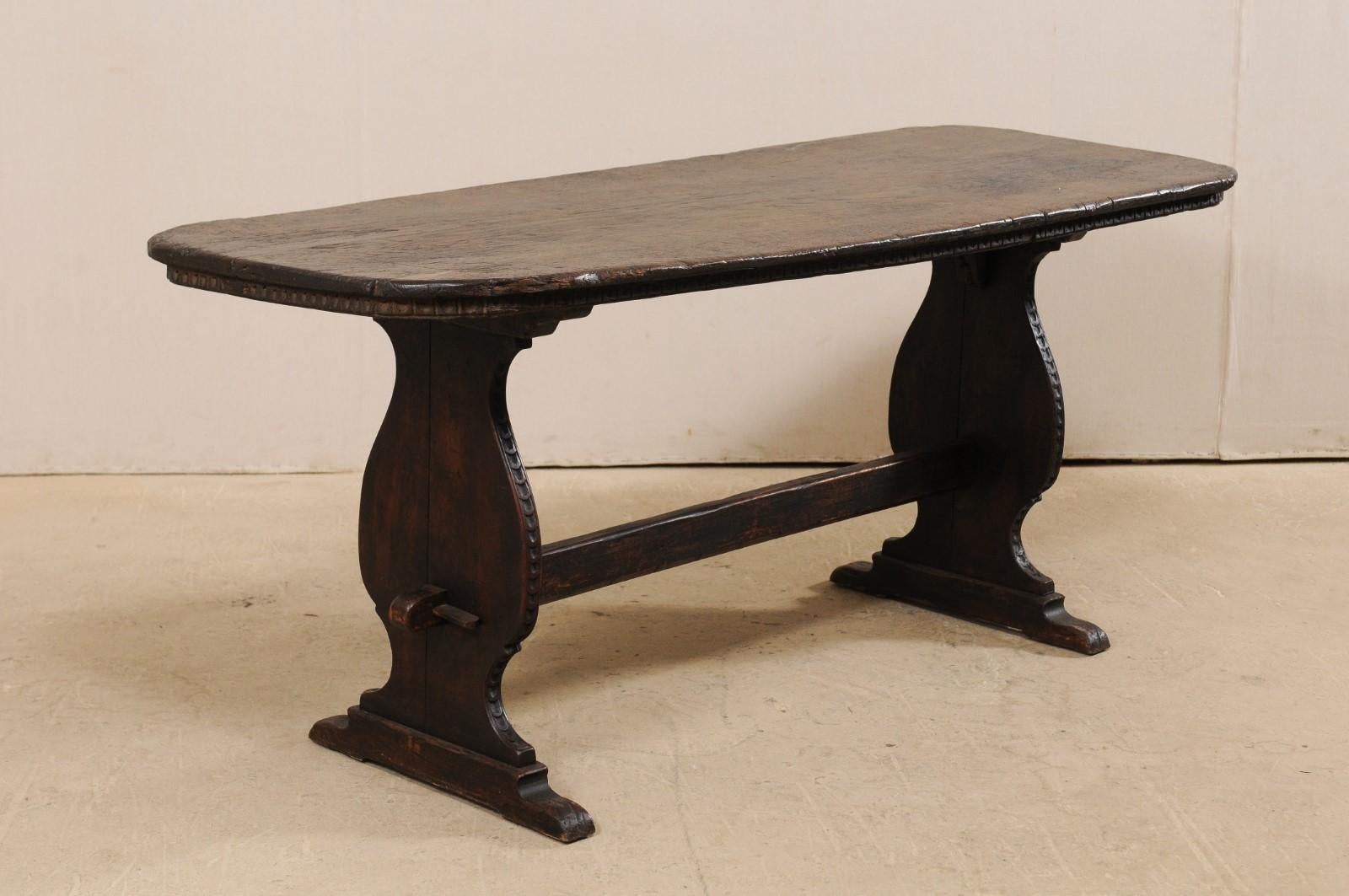 An Italian desk with turn of the 17th and 18th century top, raised upon 19th century legs. This handsome Italian desk of rich walnut or chestnut wood features an oblong-shaped turn of the 17th and 18th century, single-board top with fabulous egg and